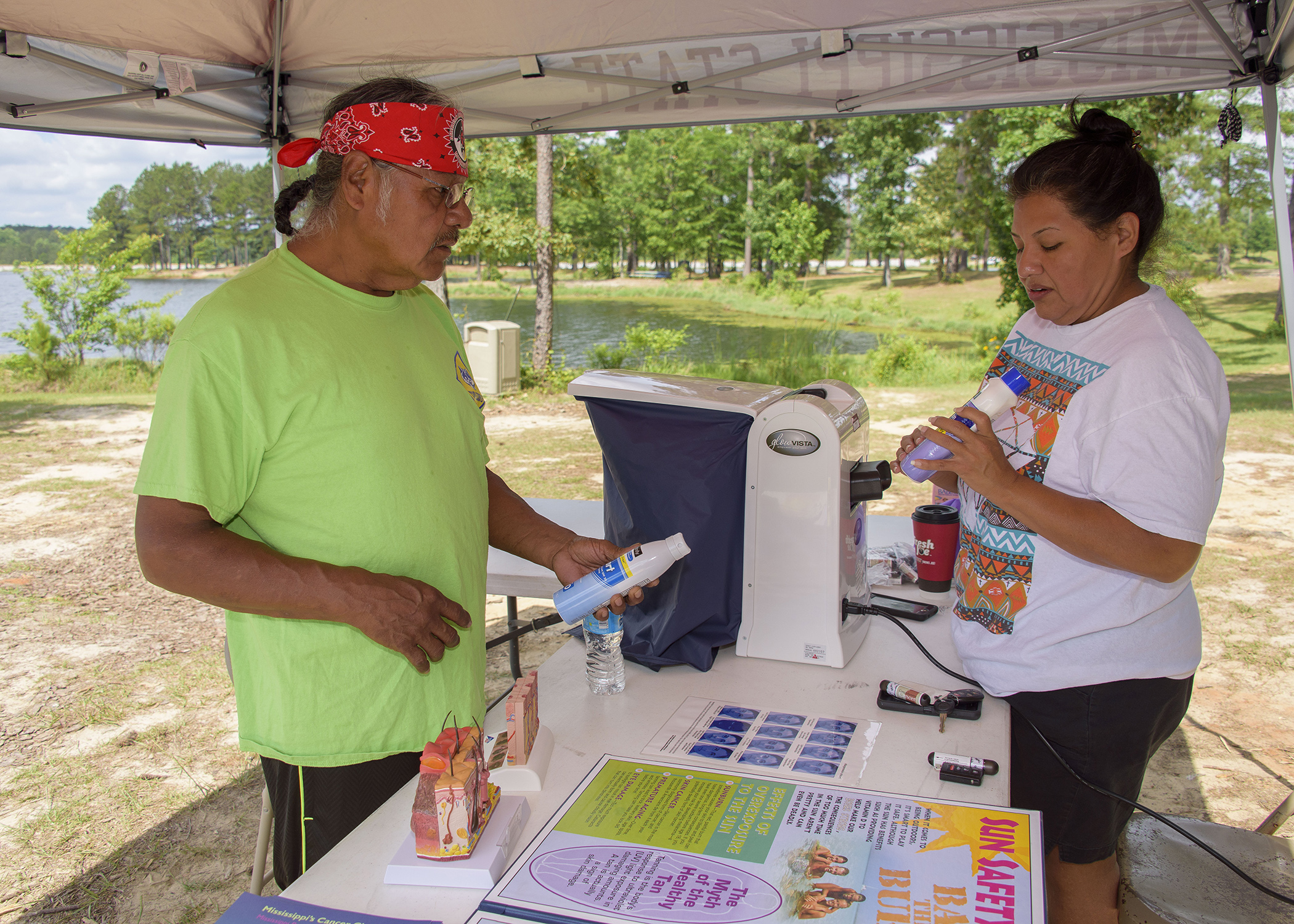 Ricky Willis learns about sun safety from Candy Jimmie at the May 28 boating event at Lake Pushmataha in Neshoba County, Mississippi. (Photo by MSU Extension Service/Kevin Hudson)