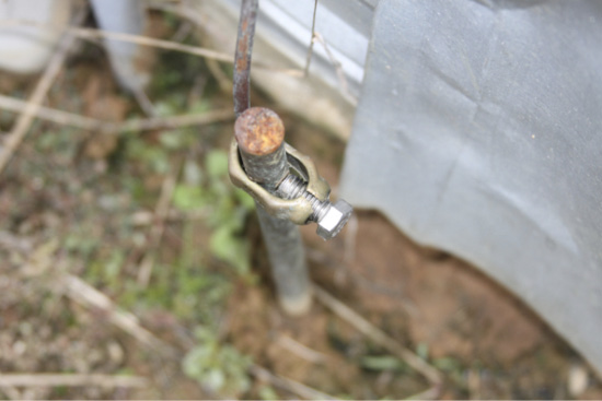 A grounding rod with a broken clamp.