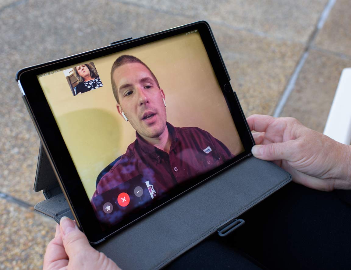 Tablet screen showing a man and woman video chatting.
