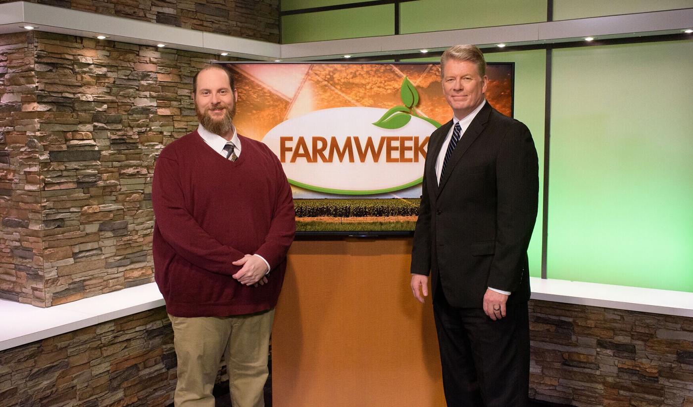2 male news anchors in Farmweek TV studio.