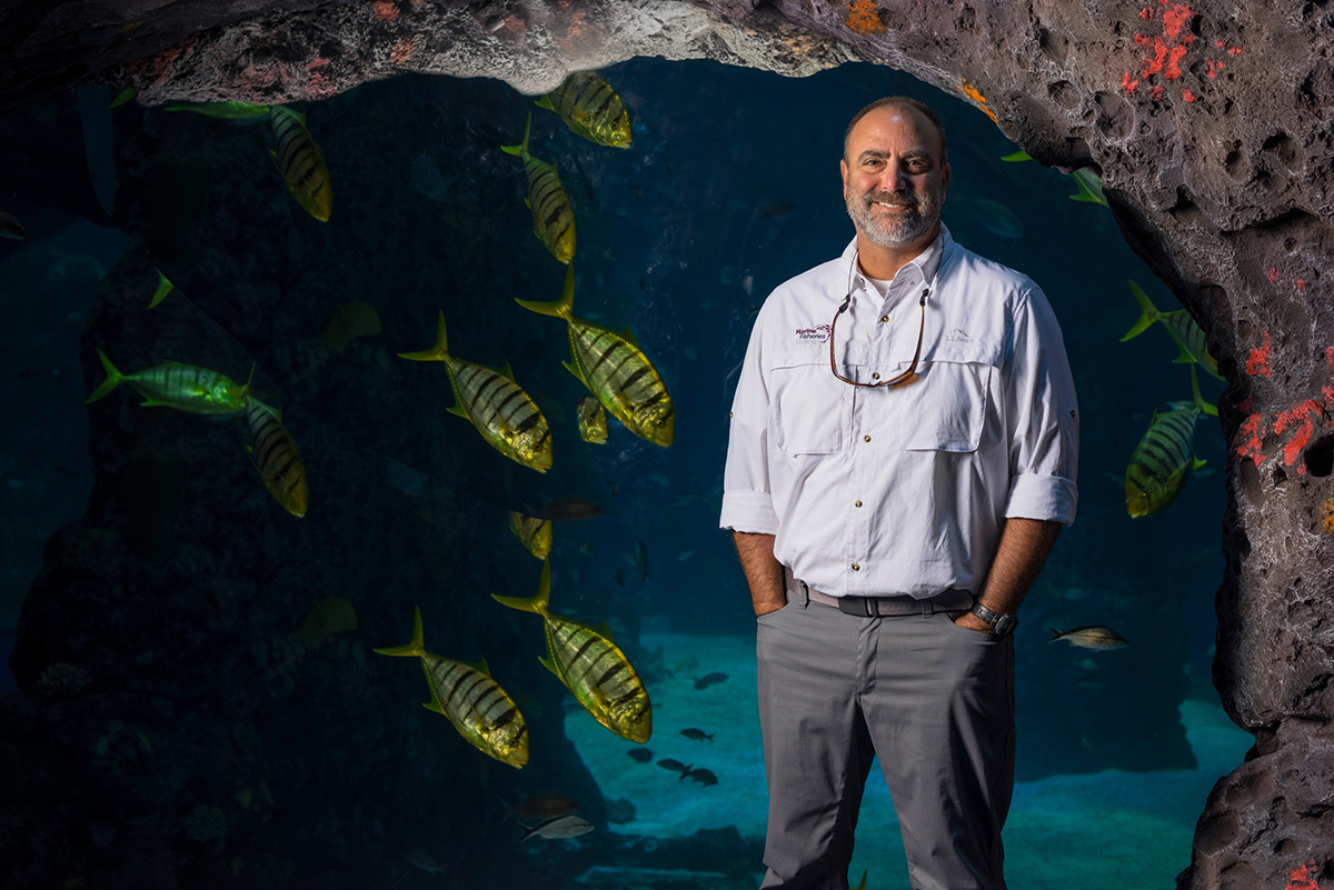Marcus Drymon standing in front of aquarium fish tanks.