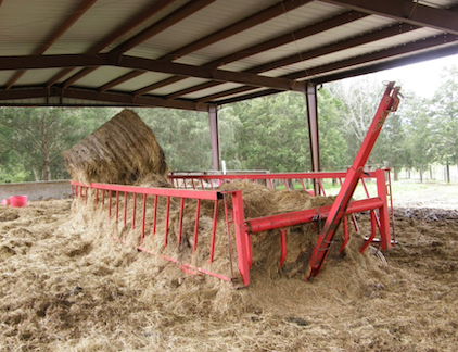 Red metal cage filled with hay.