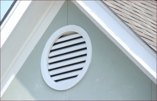 A circular gable vent on the end of a house.