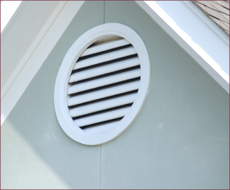 A circular gable vent on the end of a house.