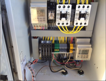 An electrical panel with different colored wires and two timers.