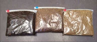 Three plastic bags of compost of different colors (dark brown, medium brown, and light brown).