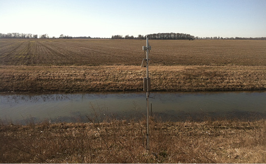 TWR ditch in winter (January). The ditch is full of water, and the surrounding field is brown.