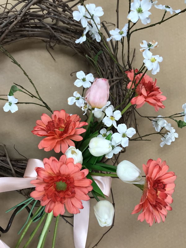 More pink and white flowers on grapevine wreath.