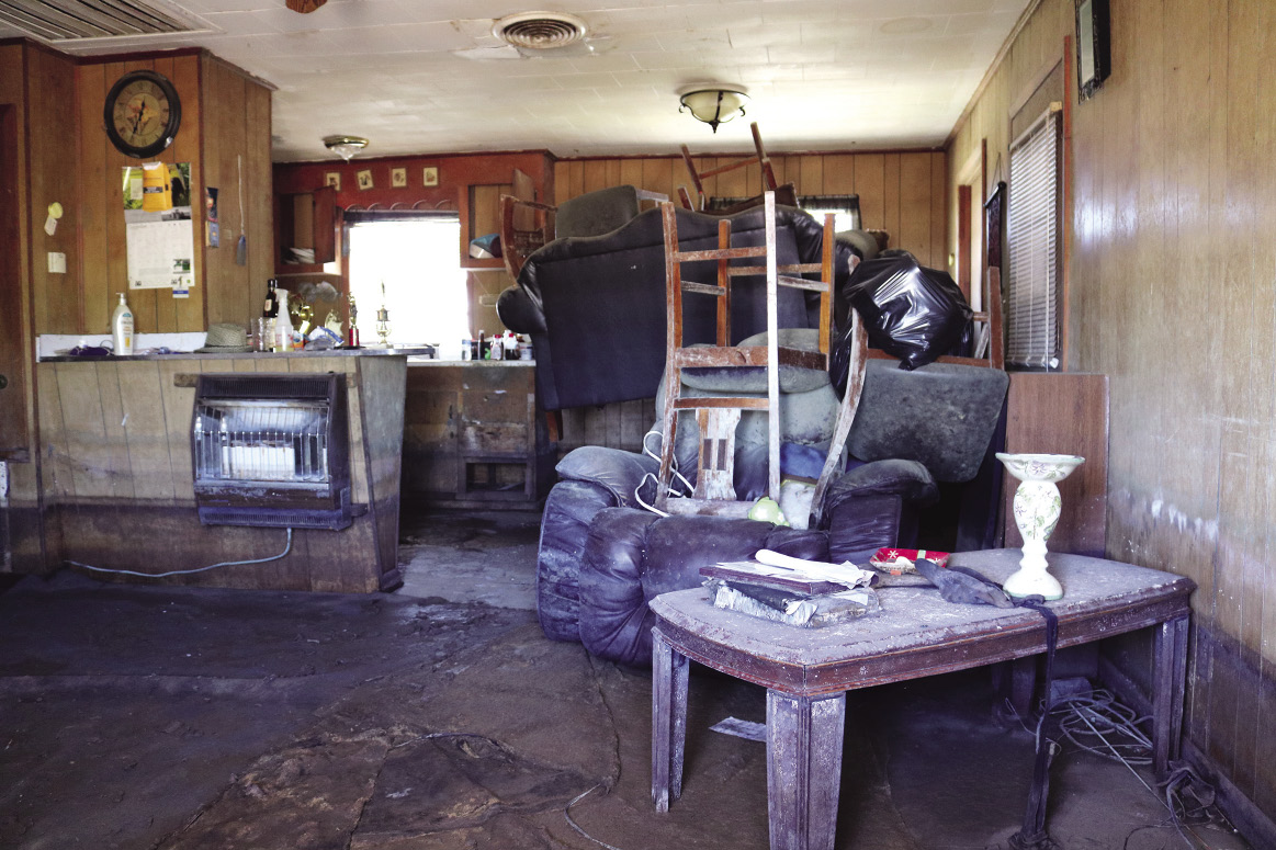 Furniture is piled inside a house severely damaged by flood water.