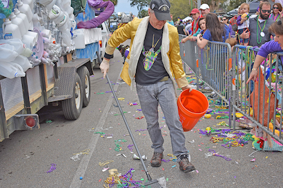 A man cleaning up trash in the street.