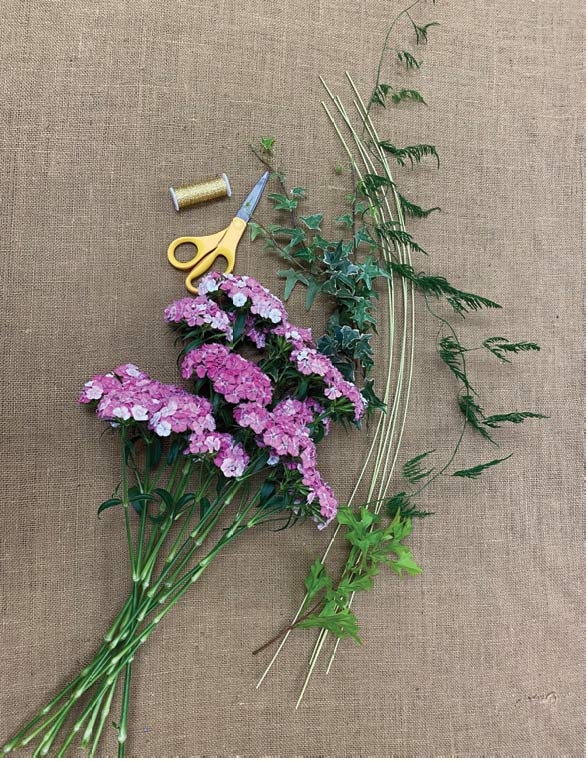 Materials necessary for a full dianthus bouquet including dianthus stems, bullion wire, floral shears, ivy, oak stem, midollino sticks and plumosa.
