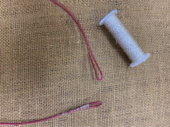 Close up photo of the ends of the floral wire bent into small loops on both ends displayed on burlap cloth. Thread is bound around each end to secure the loops.

