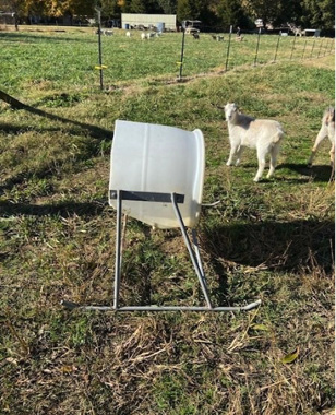  A round, white, plastic container attached to a metal stand. 