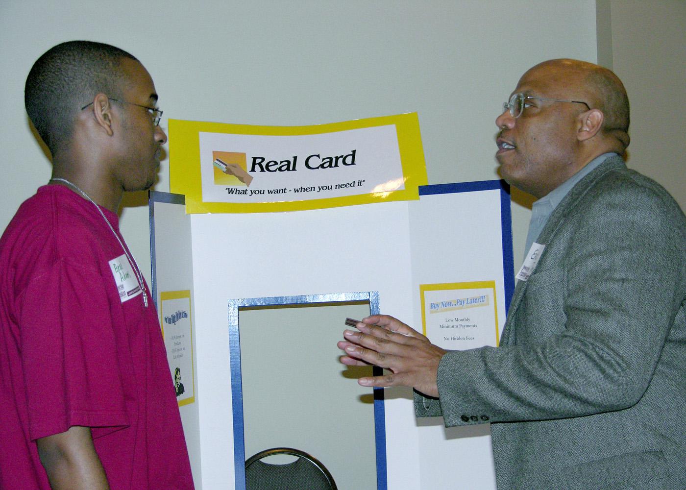 Brad Adams, a member of the Grenada High School's 4-H Leadership Club, listens to his options for a credit card from Eric Tate, playing the role of a credit card company representative in a Reality Check simulation. Tate, the director of human resources at Heatcraft in Grenada, was a resource volunteer assisting in a real-life simulation designed to enhance financial lessons.