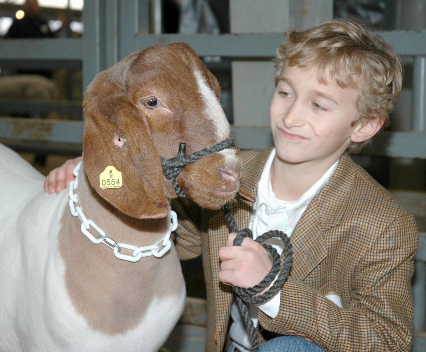 Tate County 4-H member Canan McKellar, age 9, spends a moment with his grand champion goat before entering the arena at the Dixie National Sale of Junior Champions. The goat, which was the champion mediumweight goat, brought a sale record $80 per pound for a total of $7,200.