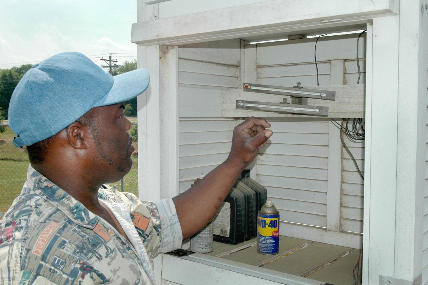 Carl Blair checks thermometers that record the 24-hour high and low temperatures.