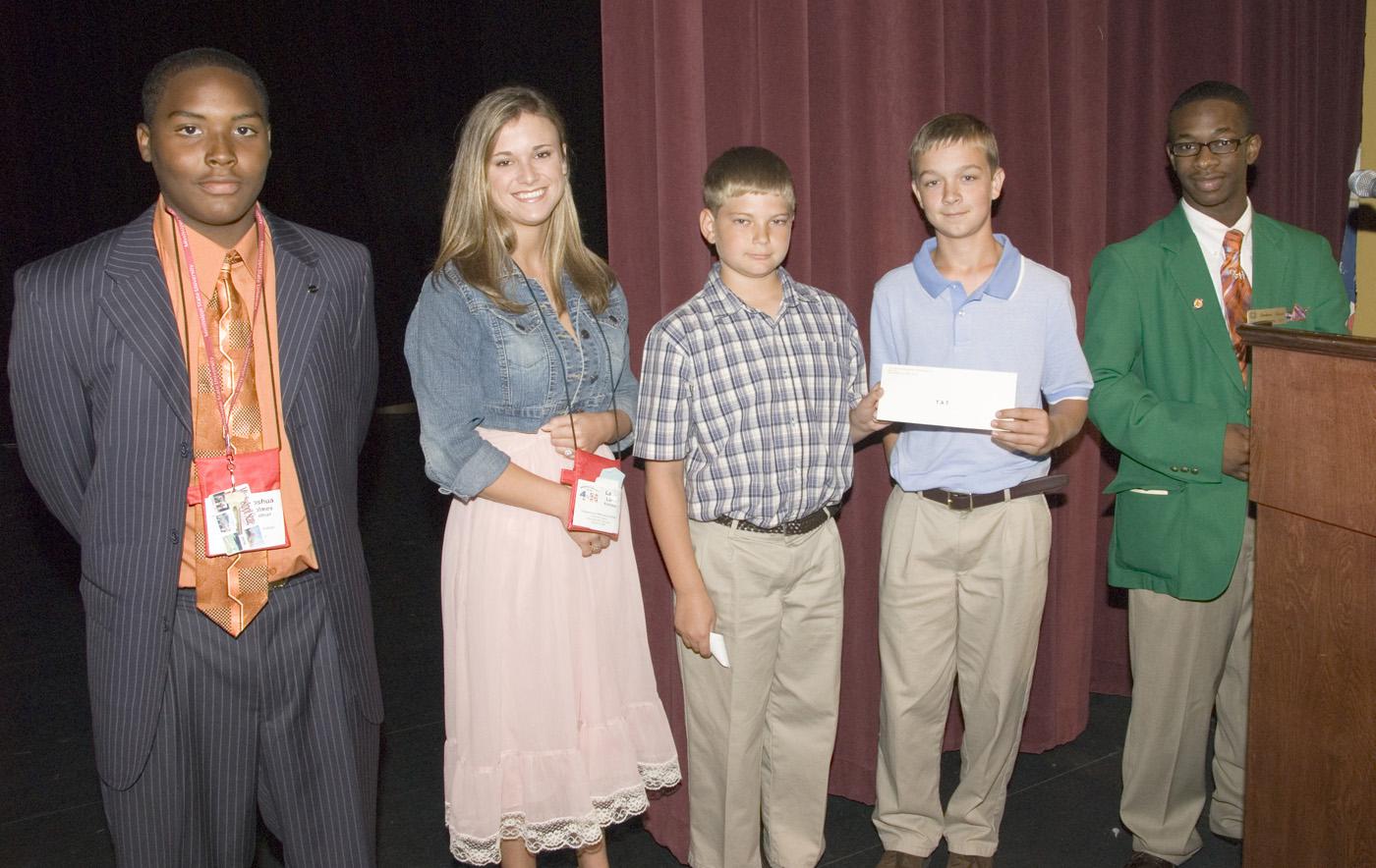 Joshua Holmes of Walthall County, from left, and Laci Lunn of Pontotoc County, represented the state's top two fund-raising counties at the 2007 4-H Congress. They presented a check to Alabama 4-H members Buddy Skipper and Ben Jones, both sixth graders from Enterprise. Leadership Team member Cord Davis of Bolivar County assisted in the presentation. (Photo by Marco Nicovich/MSU Ag Communications) Larger view.