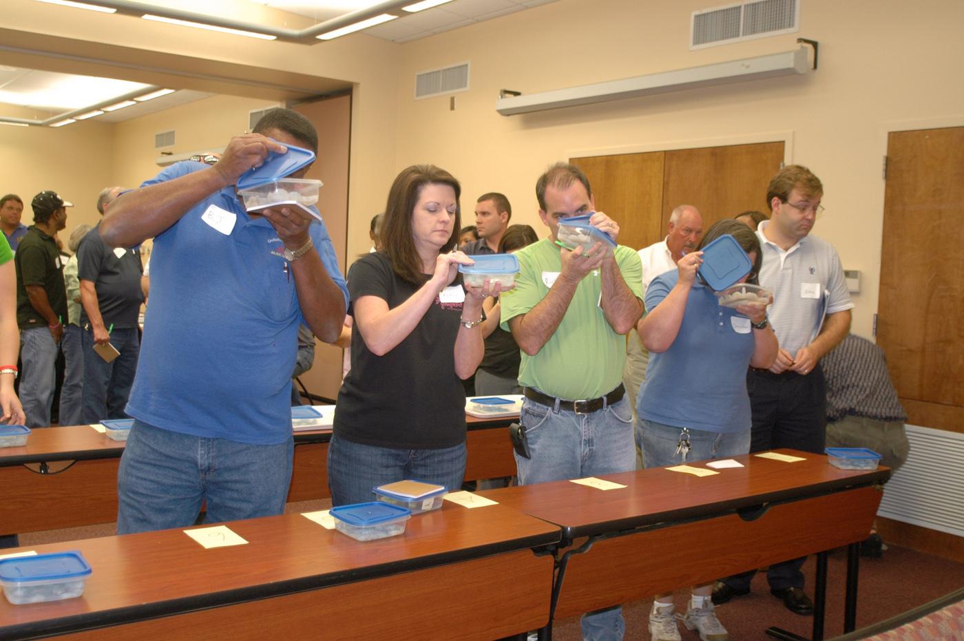 Participants in a recent Harvest from Open Waters training in Biloxi line up to sniff samples of shrimp and grouper spiked with oil in concentrations as low as 5 parts per million and less. (Photo by Karen Templeton)