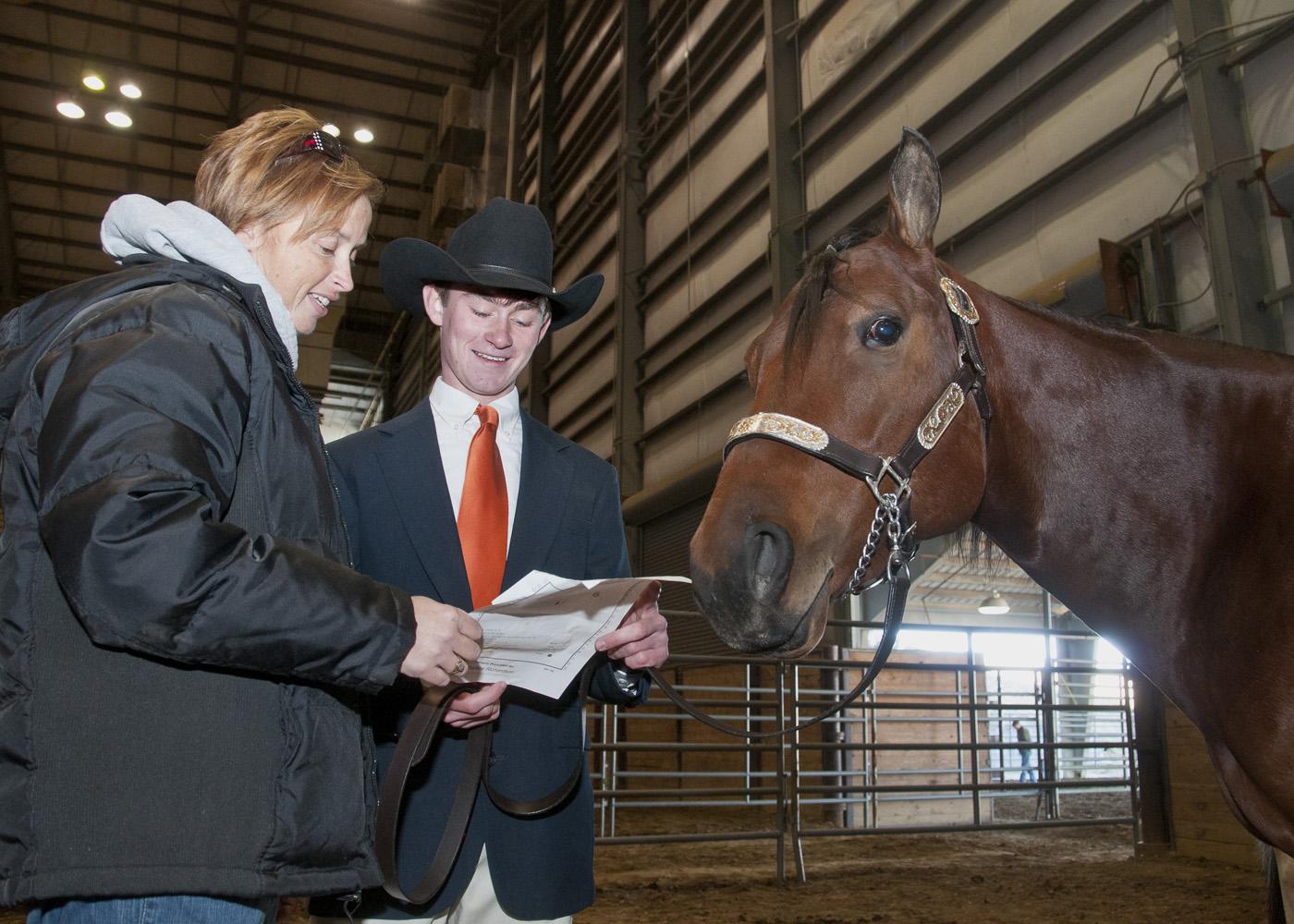Union County 4-H youth agent Gina Wills and 4-H member Bobby May of Marshall County review the show schedule for the Winter Classic Horse Show held at the Mississippi Horse Park near Starkville. May and his horse, Jack, took part in the series of off-season shows from January through March. (Photo by Scott Corey)