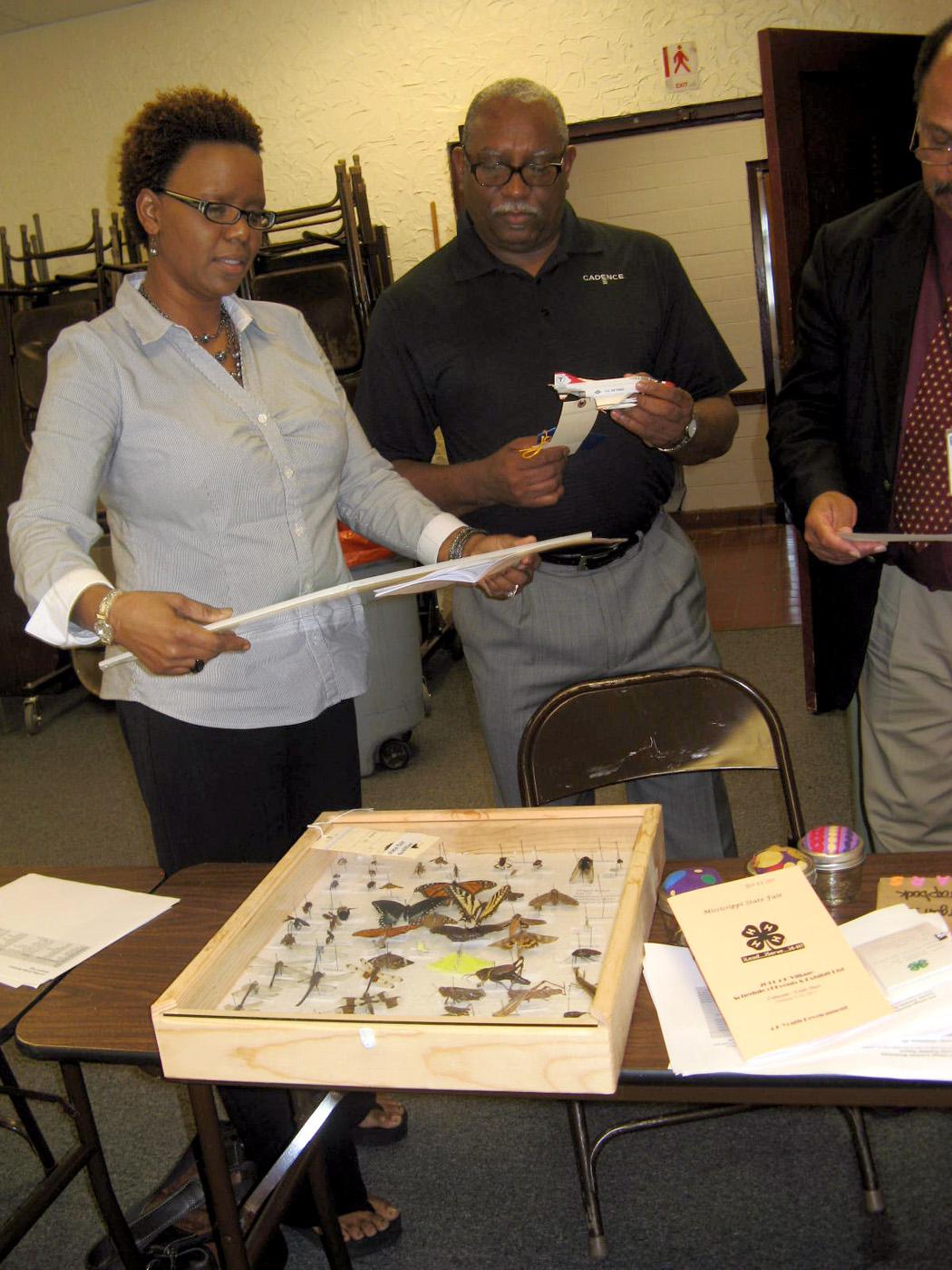 Oktibbeha County 4-H Advisory Council President Angela Burress Stewart, a volunteer leader with the Longview Disciples 4-H Club, is the recipient of the salute to excellence volunteer of the year award from Mississippi 4-H. She and council member Victor Evans, both of Starkville, review insect collections and other items going to the 2011 State Fair in Jackson. (Submitted photo)