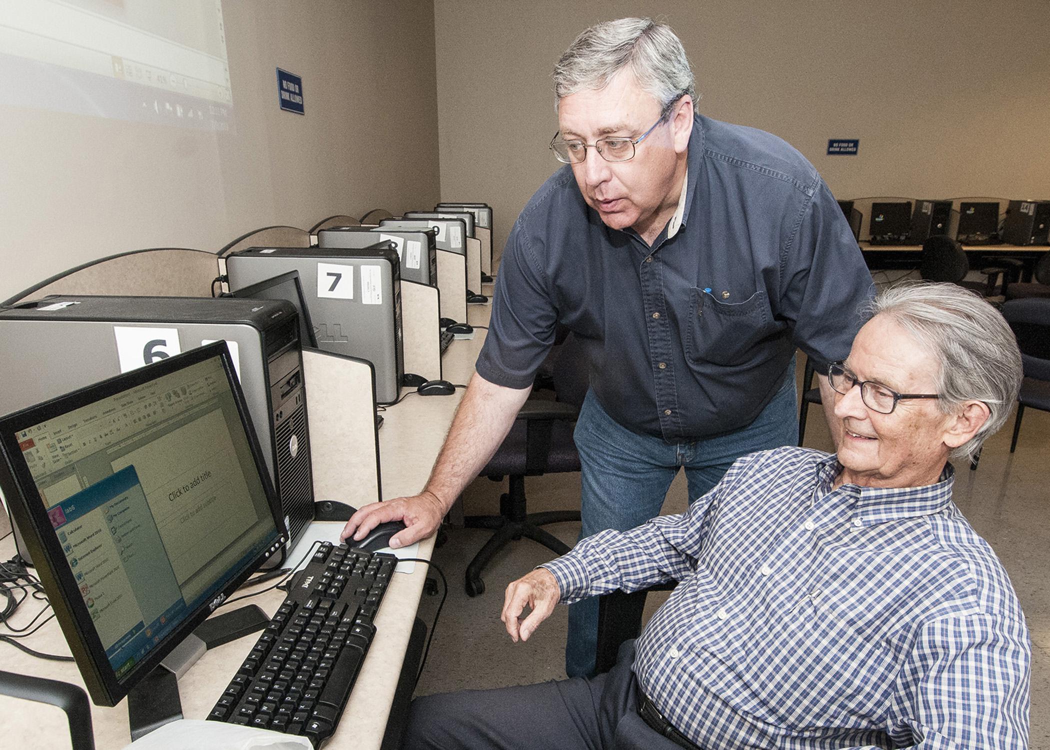 As part of an ongoing program of computer skills workshops, John Giesemann with the Mississippi State University Extension Service Center for Technology Outreach shows Vern Boothe how to access a slideshow program at the WIN Job Center in Madison on July 9, 2013. (File photo by MSU Ag Communications/Scott Corey)