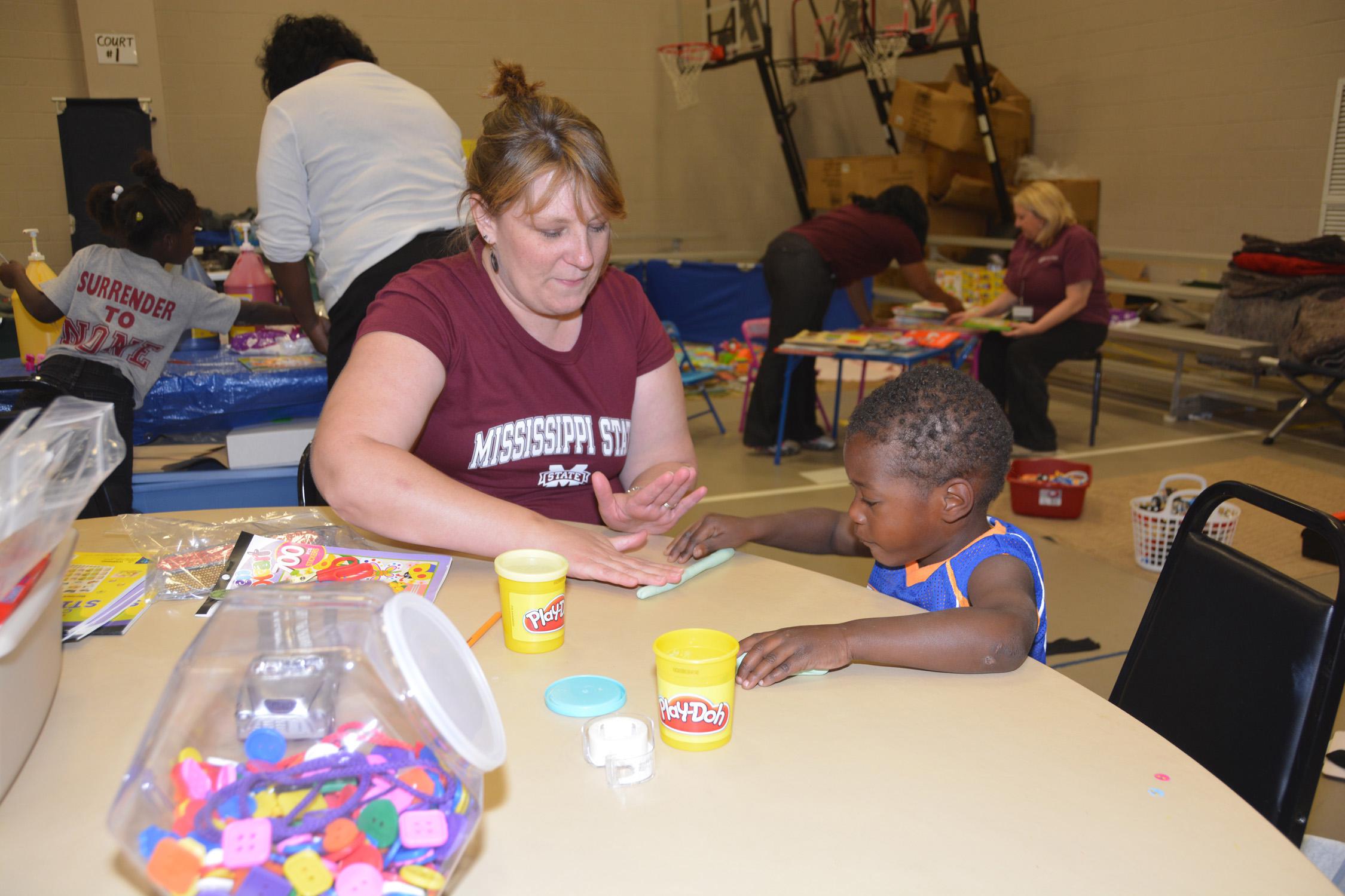 Gina Carr, a Mississippi State University Extension Service staff member with the Mississippi Child Care Resource and Referral Network, keeps 3-year-old Brandily Haynes engaged while his family is in the American Red Cross Shelter at First Baptist Church in Louisville, Mississippi, on May 1, 2014.  (Photo by MSU Ag Communications/Linda Breazeale)