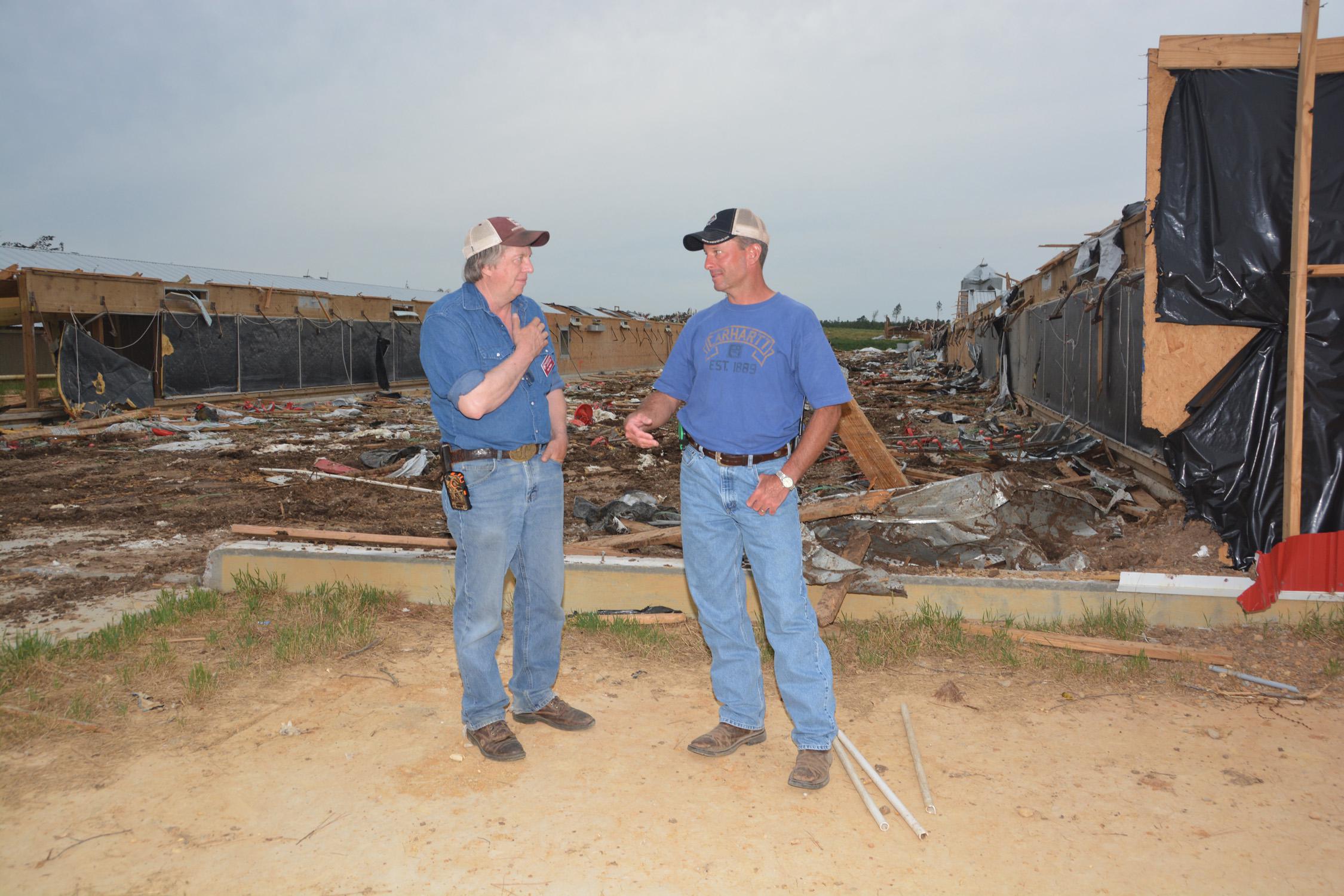 Mississippi State University Extension Service poultry specialist Tom Tabler, left, visits with Winston County poultry grower Tim Hobby on May 8, 2014. Hobby lost 10 broiler houses in the April 28 tornado. (Photo by MSU Ag Communications/Linda Breazeale)
