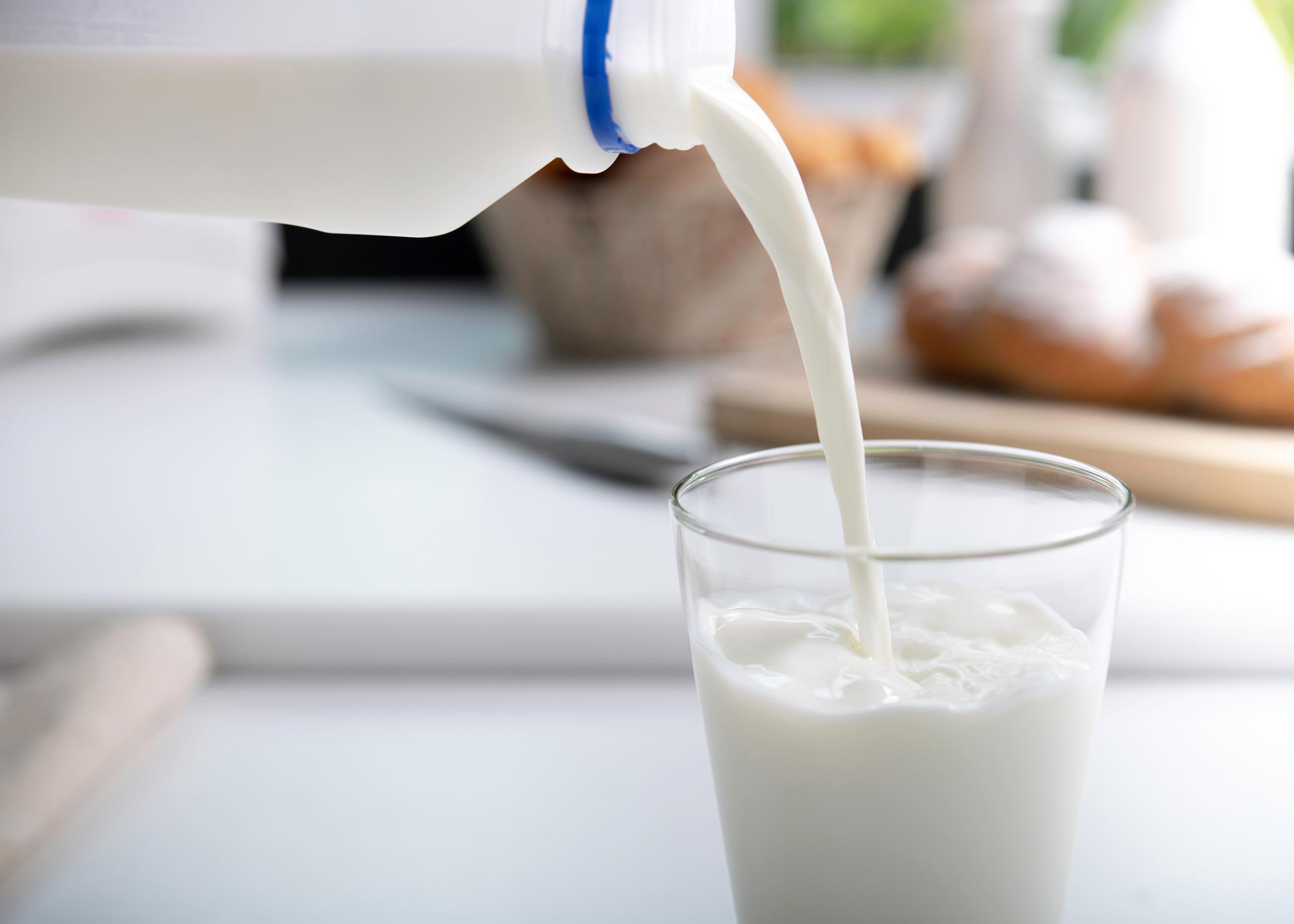 Milk is poured from a jug into a glass.