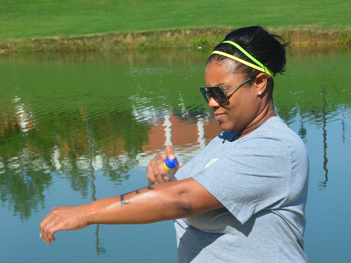 Erika Glenn of Starkville, Mississippi, does not neglect using sunscreen before exercising around Chadwick Lake on the Mississippi State University campus on June 26, 2017. (Photo by MSU Extension Service/Linda Breazeale)