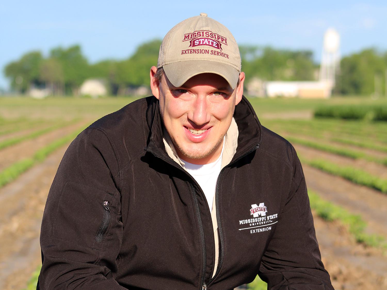 John Orlowski, a Mississippi State University assistant research and Extension professor, inspects soybean seedlings in a plot at the Delta Research and Extension Center in Stoneville. Orlowski will coordinate the first Mississippi Soybean Yield Contest. (Photo by MSU Delta Research and Extension Center/Kenner Patton)