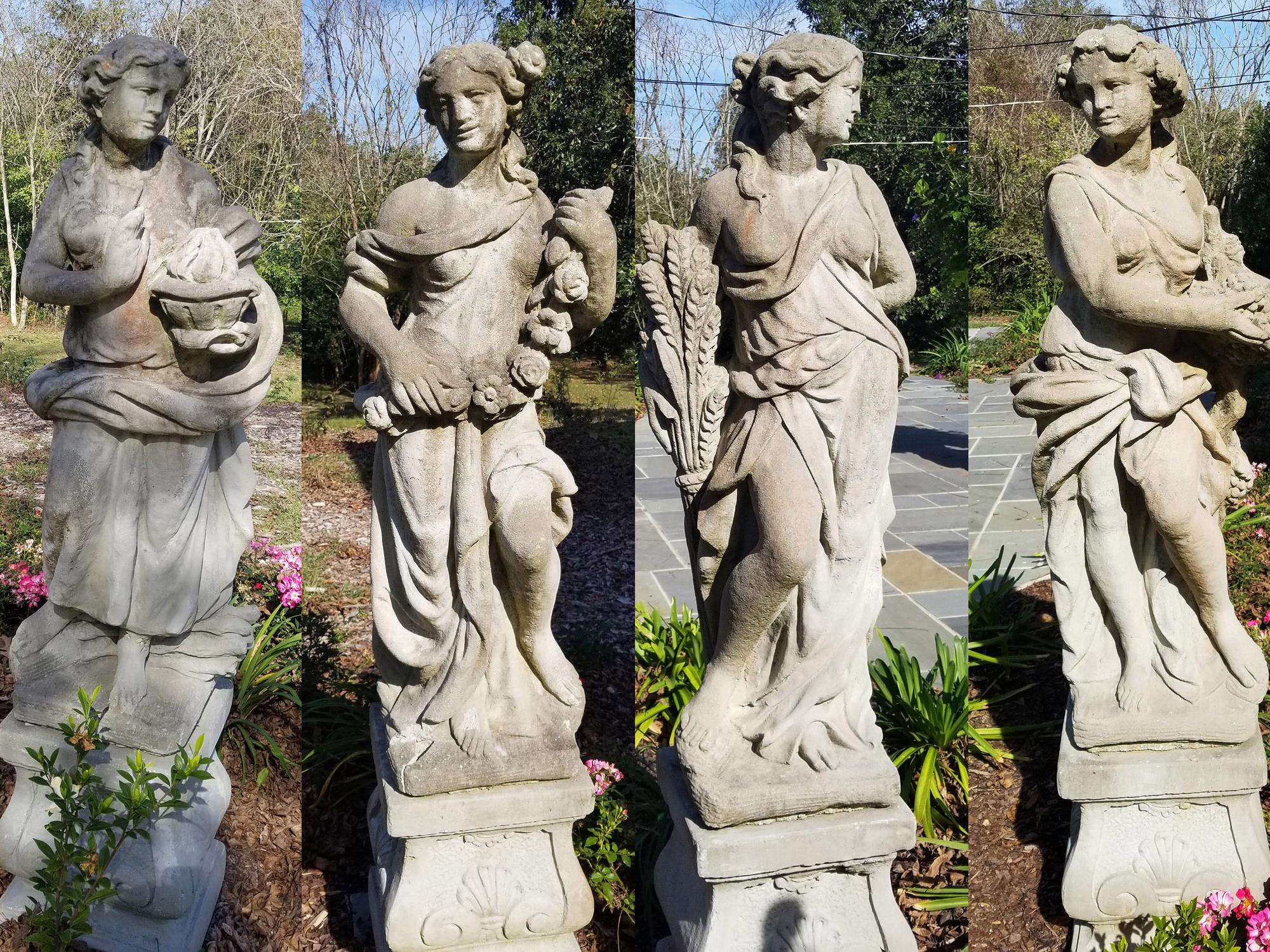 Four stone statues are seen representing ancient Greek goddesses.