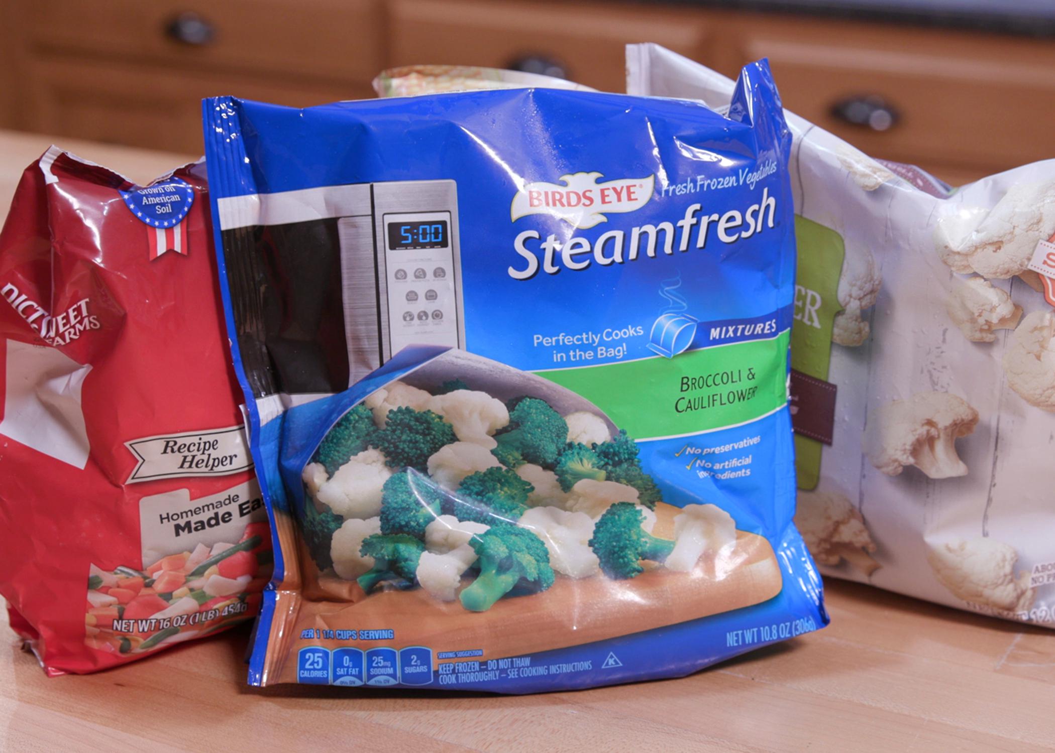Three bags of frozen vegetables sit on a counter.