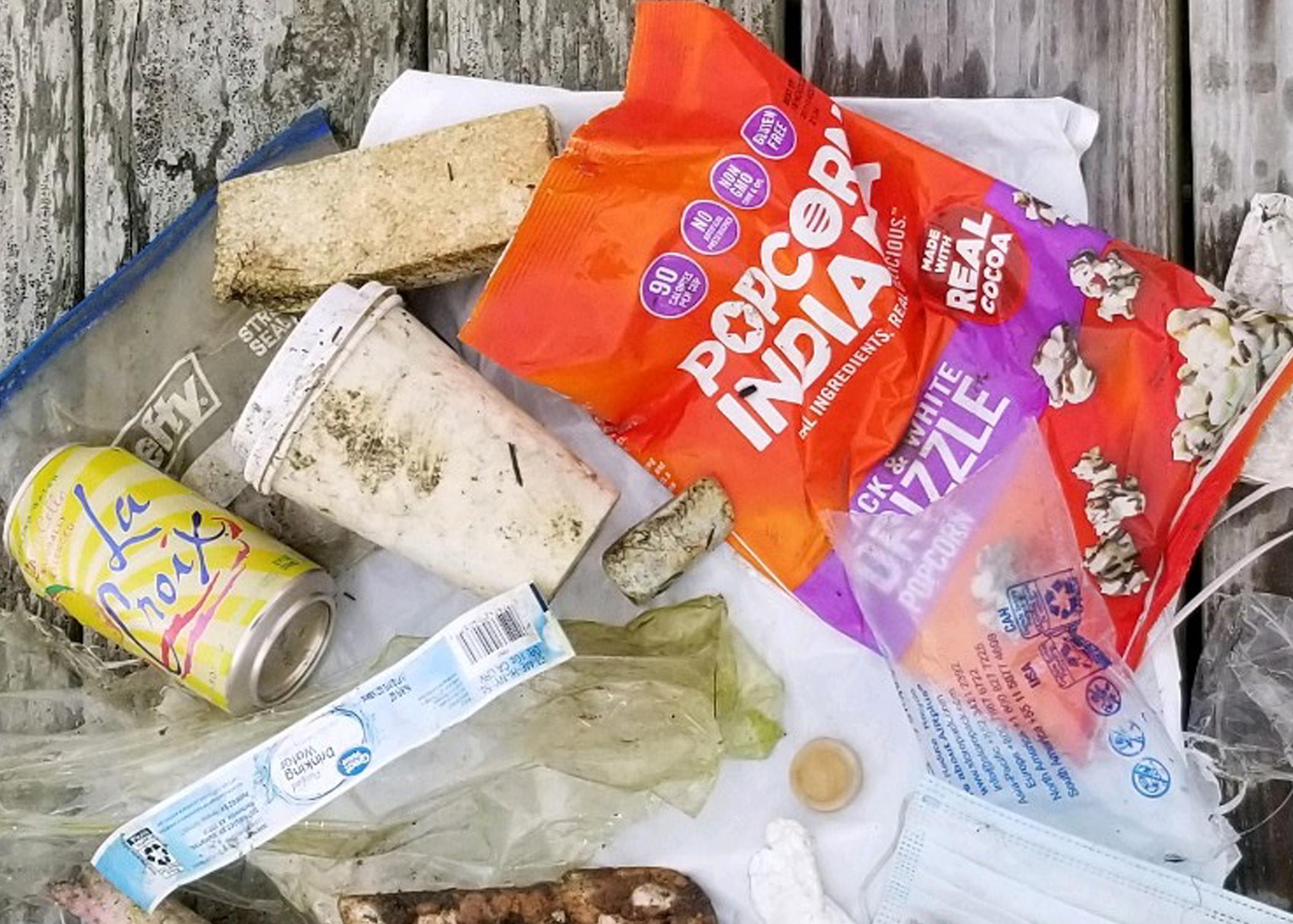 An assortment of litter retrieved from a watershed displayed on a wooden dock. 