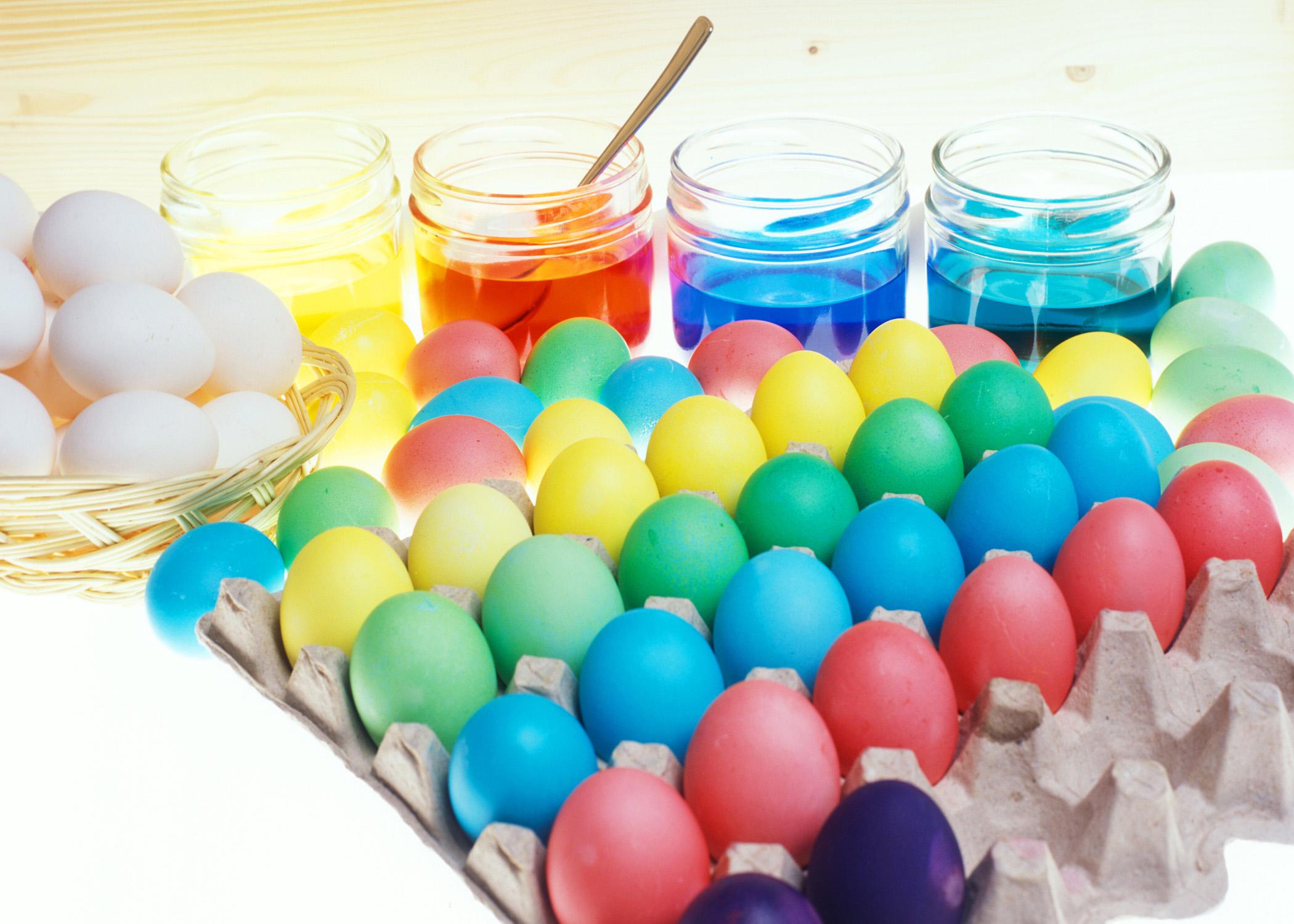 Dye, eggs and dyed eggs on a counter.