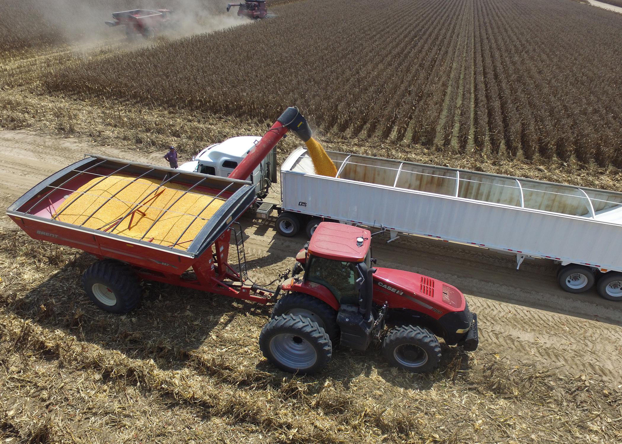 Aerial view of a tractor and a load of grain being transferred.