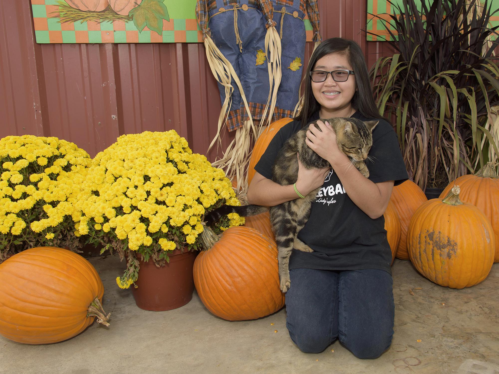 Katy Chen of Louisville, Mississippi, holds the unofficial mascot of May’s Corn Maze in Stewart, Mississippi, in front of the agritourism farm’s pumpkin patch. The state enjoyed a strong pumpkin harvest for the second straight year. (Photo by MSU Extension Service/Kevin Hudson)