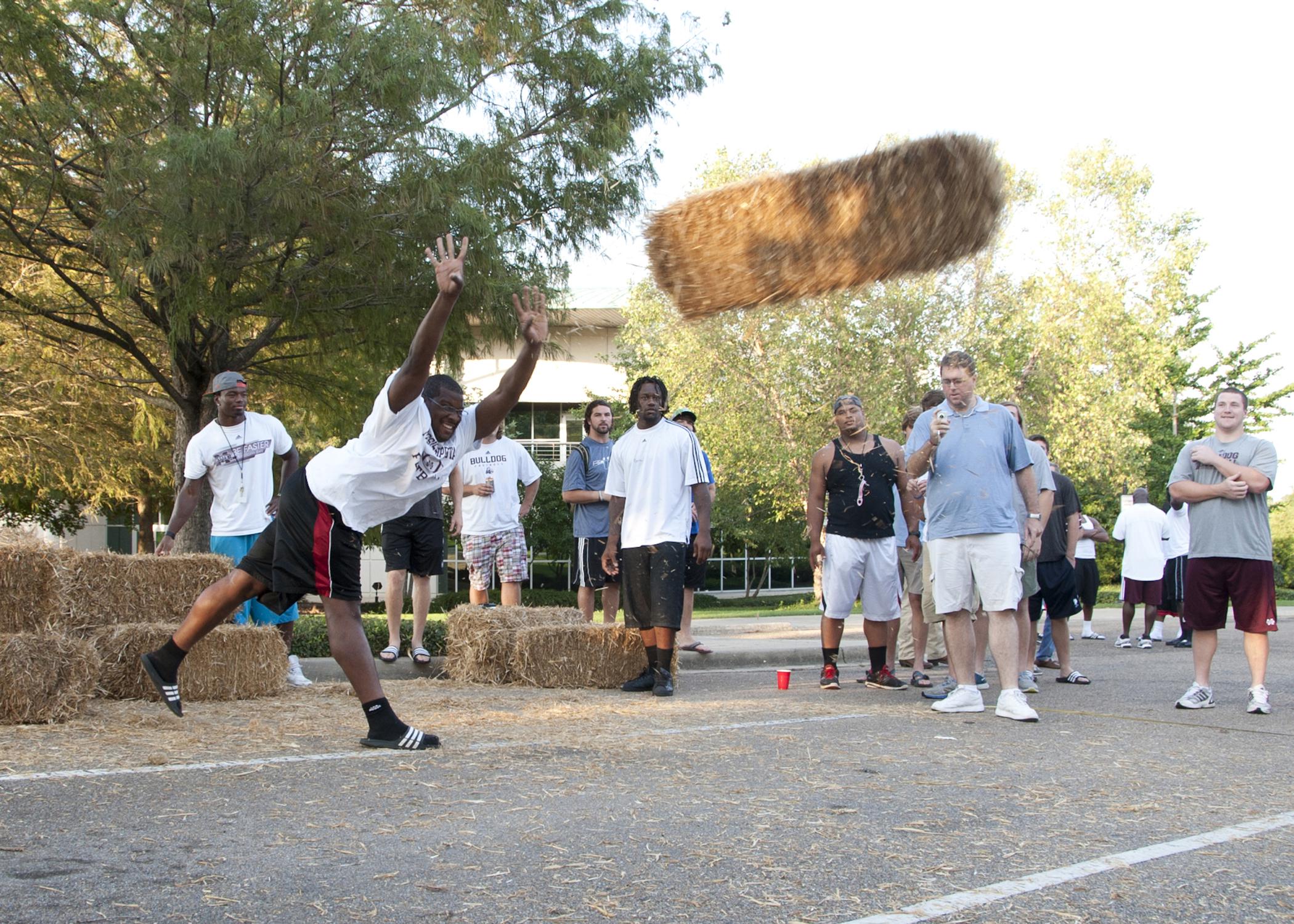 Mississippi State University defensive lineman Kaleb Eulls of Yazoo City defends his title as returning hay toss champion against fellow football players Sunday afternoon, Aug. 19, 2012, on the MSU campus. The second annual Beefin’ up the Bulldogs included a steak supper and activities promoting MSU’s land-grant heritage. Sponsors included First South Farm Credit, Mississippi Cattlemen’s Association, Mississippi Beef Council and MSU’s Animal and Dairy Science Department. (Photo by MSU Ag Communications/Kat 
