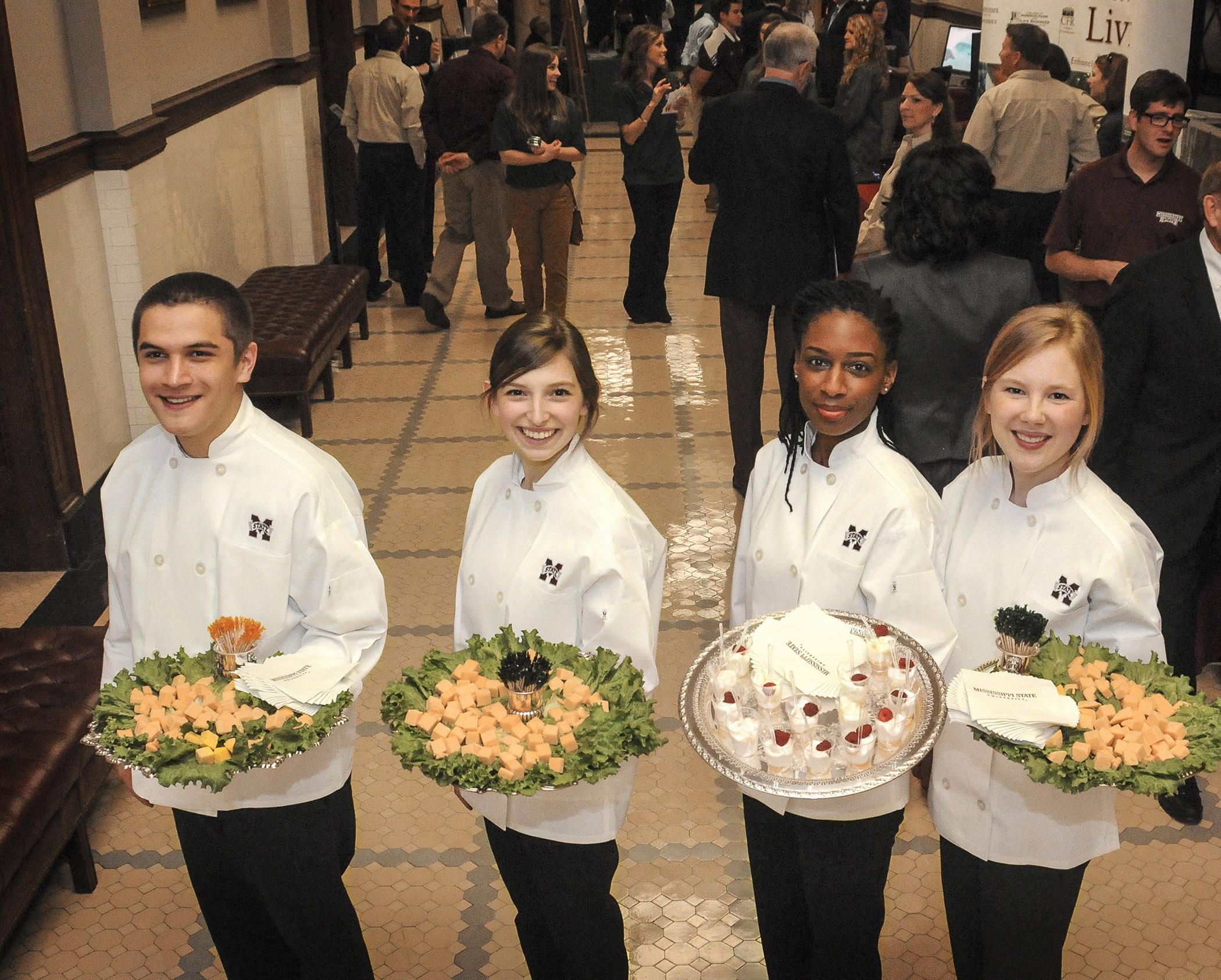 Mississippi State University food science, nutrition and health promotion students Crecencio Deleon of Hattiesburg, Anna Hansen of Long Beach, Keonshae Freeman of Biloxi and Shelly Johnston of Mount Olive serve Edam cheese and Greek yogurt March 6, 2013 at the Institutions of Higher Learning Day at the State Capitol in Jackson. (Photo by MSU Ag Communications/Scott Corey)