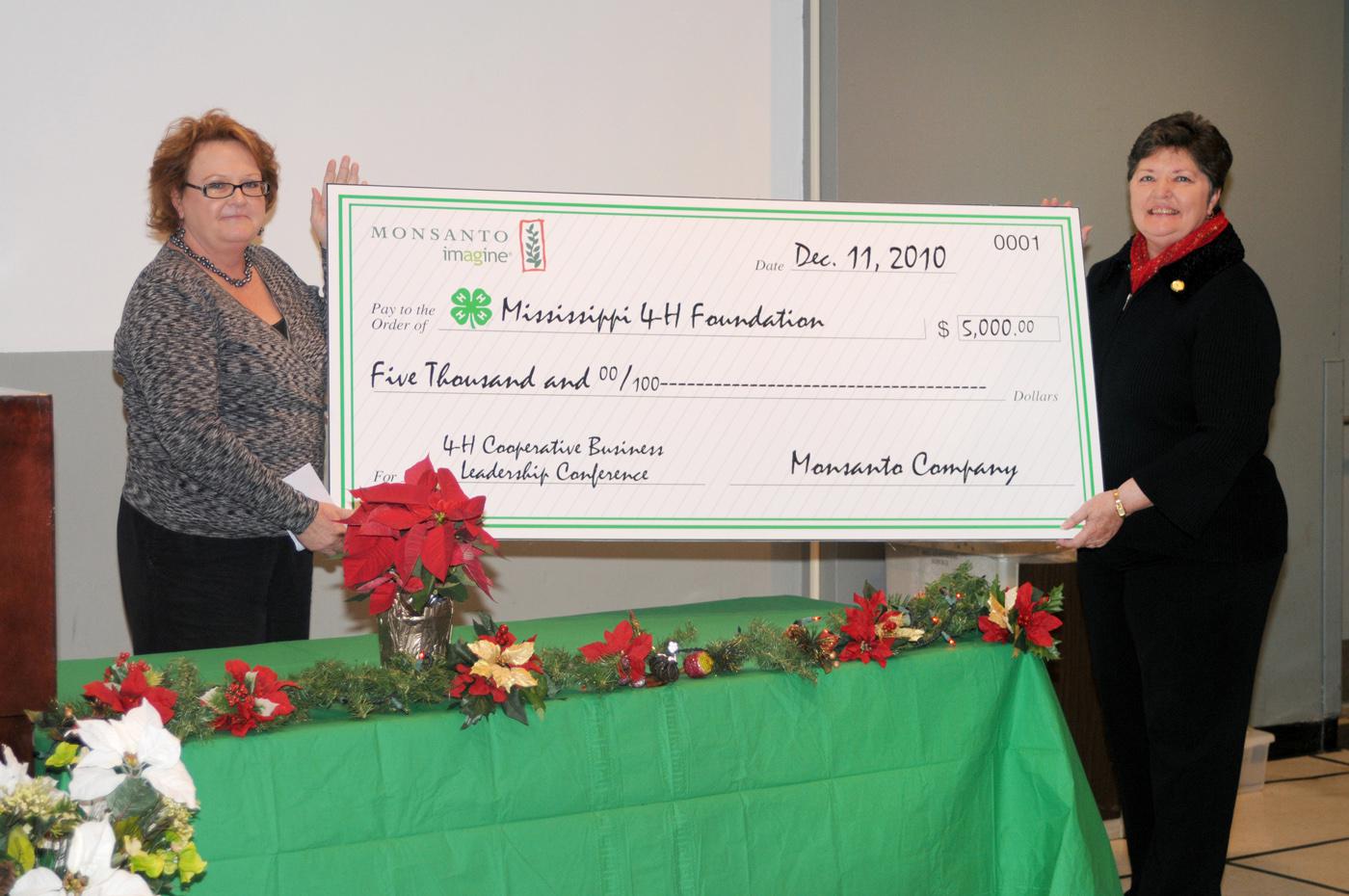 Monsanto Co. representative Derenda Stanley, left, presents Susan Holder a ceremonial check for $5,000 in support of 4-H. Holder, director of the 4-H Youth Program with the Mississippi State University Extension Service, said the funds will support the 4-H Cooperative Business Leadership Conference in 2011. This annual event is the reward given to senior-level 4-H members who placed first in their state competitions at 4-H Congress and state 4-H leadership team members. The primary objective of grants from 