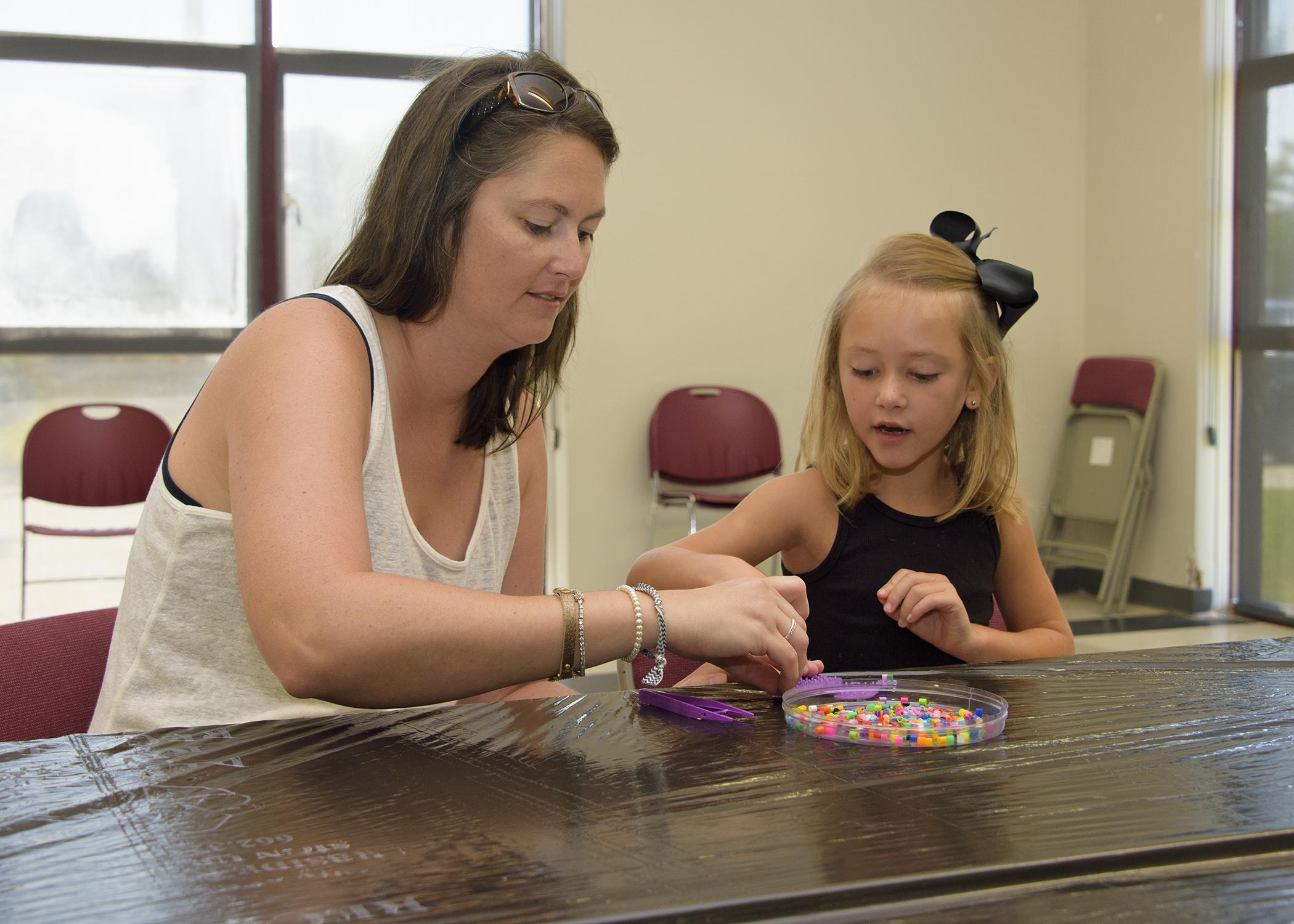 A parent's involvement can make any activity a learning experience. Jaden Claire Everett, 5, fashions a dog out of beads as her mother, Jana Carolyn Everett, assists. (Photo by MSU Ag Communications/Kevin Hudson)