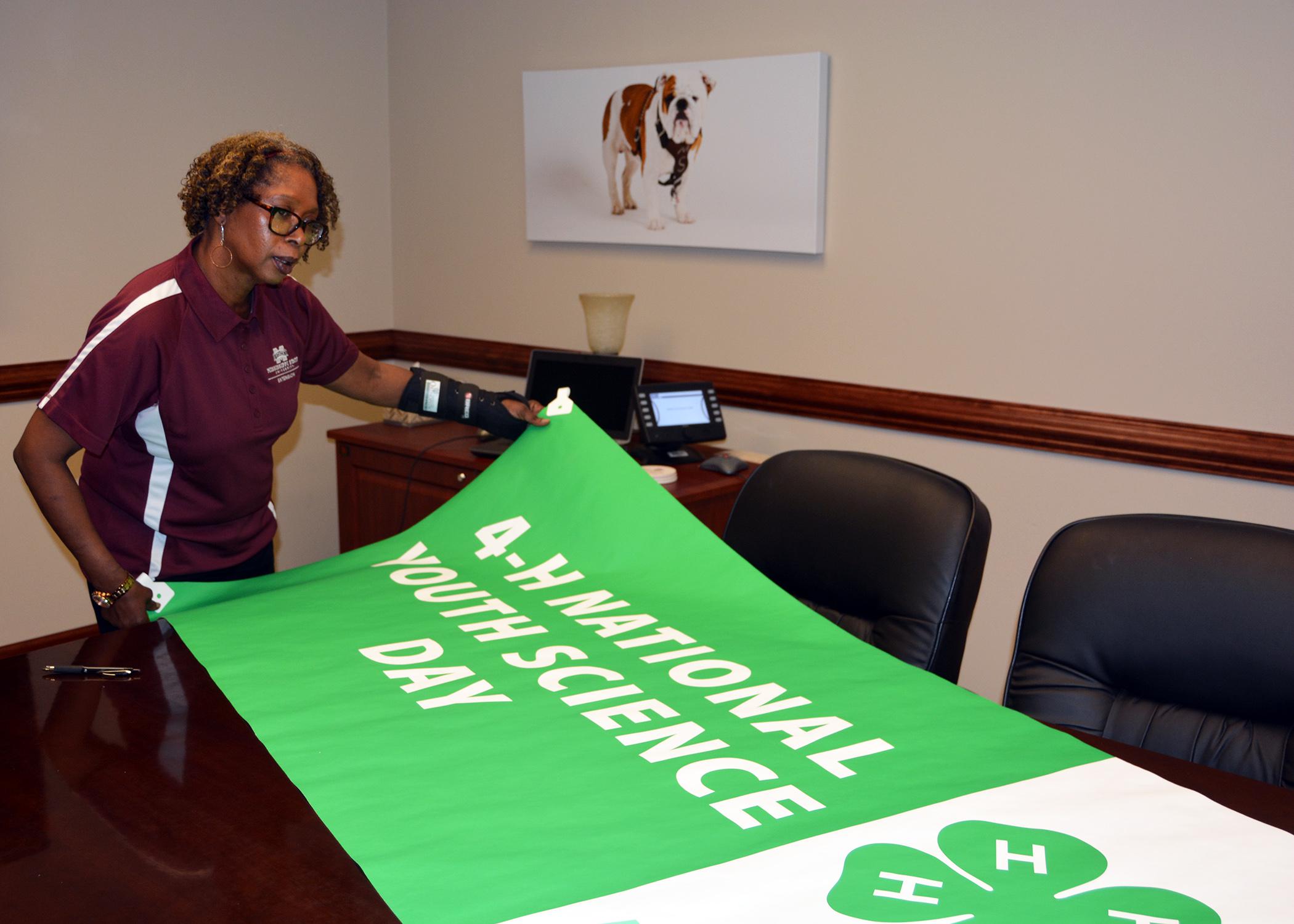 Paula Threadgill, associate director of the Mississippi State University Extension Service and state leader of 4-H, reviews a poster that will hang in the 4-H Village in the Trademart in Jackson during the Mississippi State Fair from Oct. 7-18. The photo was taken at MSU on Oct. 2, 2015. (Photo by MSU Ag Communications/Linda Breazeale)