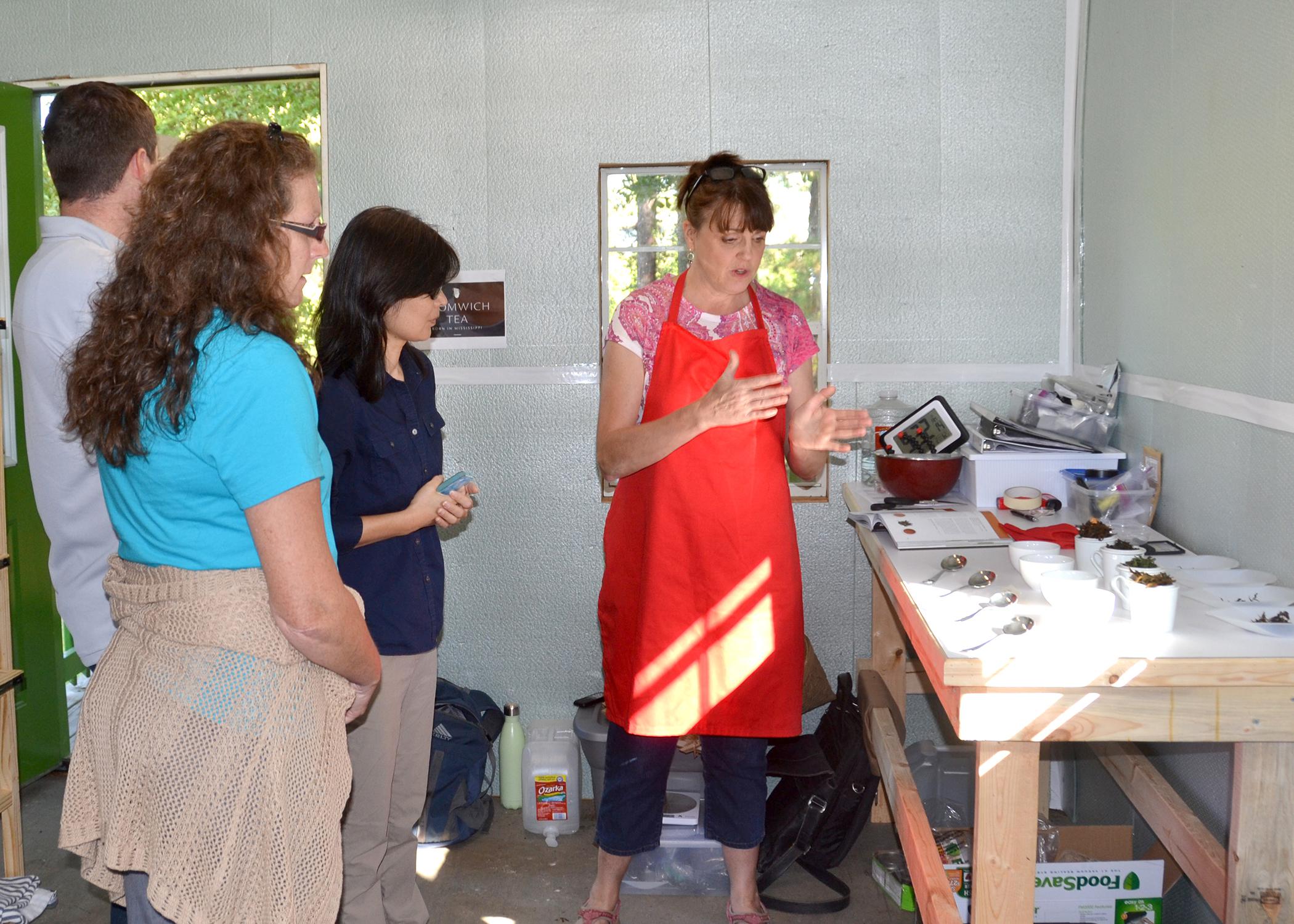 Donna Beliech, horticulture agent with the Mississippi State University Extension Service; Judson Lecompte, MSU research associate, and Guihong Bi, MSU associate research professor, listen as tea blender Beverly Wainwright explains the process of developing tea blends at The Great Mississippi Tea Company in Brookhaven, Mississippi, on Oct. 2, 2015. Wainwright is working with other tea consultants to make unique tea blends for the company. (Photo by MSU Ag Communications/Susan Collins-Smith)