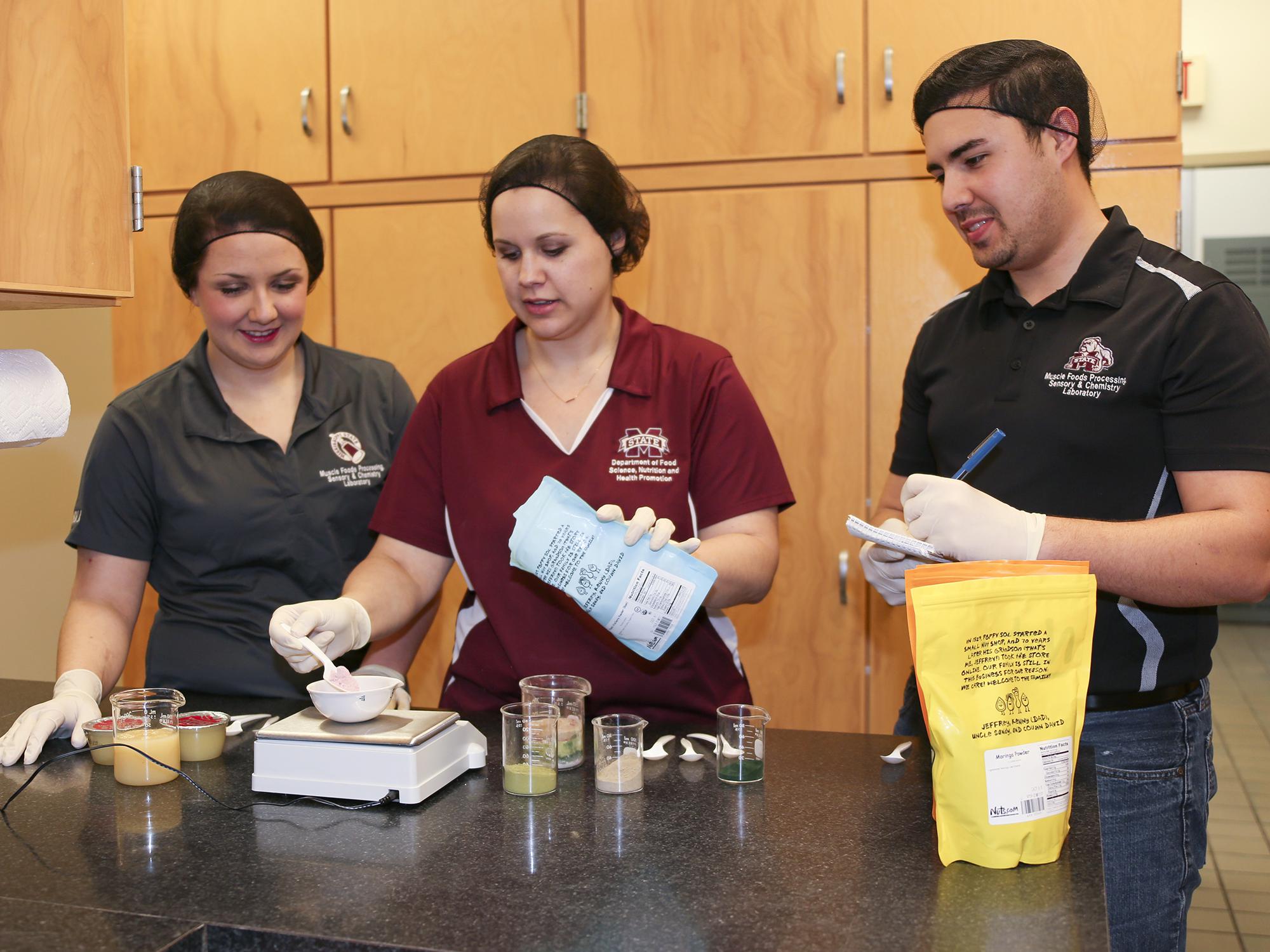 Mississippi State University junior Morgan Von Staden of Olive Branch, Mississippi, and graduate students Liz Ivey of Cumming, Georgia and Hector Portillo of Sarasota, Florida are members of a Department of Food Science, Nutrition and Health Promotion student team developing a product made of culled sweet potatoes that cafeterias could use to increase the nutritional value of school lunches. (Photo by MSU Extension Service, Kat Lawrence)