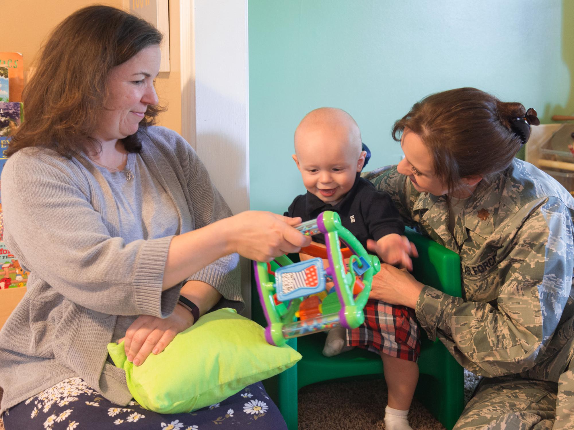 Heather Bond (left) plays with Thaddeus Pyko, while his mother, Maj. Kyla Pyko, watches. Bond is a family-home care provider who has opened her home to military families needing child care.  (Photo by MSU Extension Service/Alexandra Woolbright)