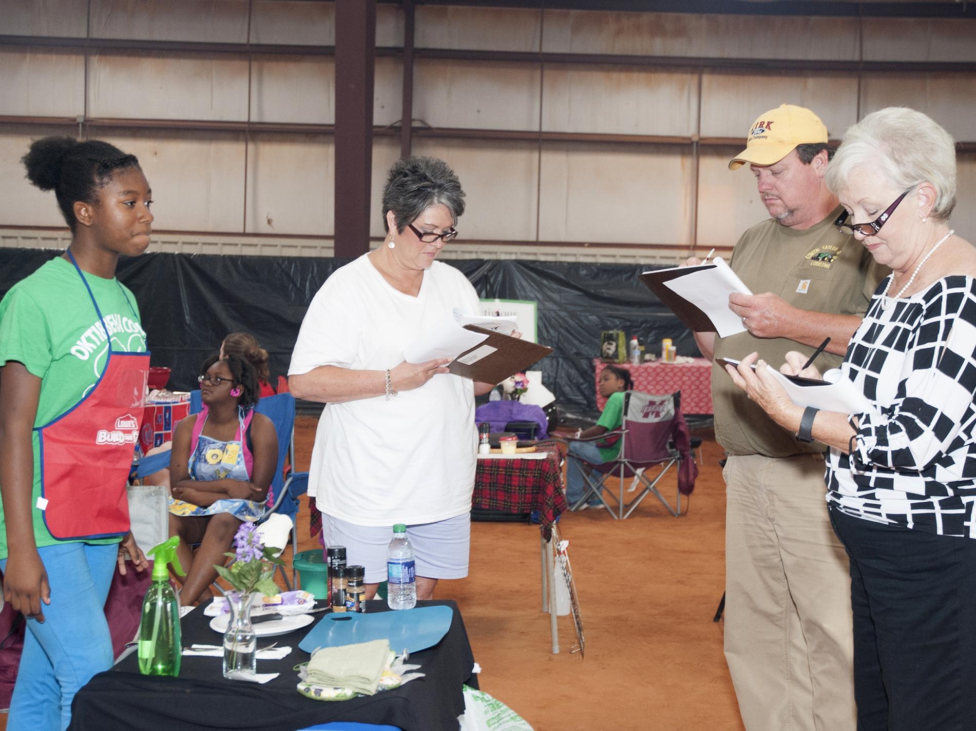 Oktibbeha County 4-H member Trukyra Lawrence, left, waits as judges, from left, Theresa Sproles, Edwin Taylor and Lanelle Martin evaluate her grilling area at the 2016 North Half State Cook-Off competition on June 28, 2016. (File photo by MSU Extension Service/ Kat Lawrence) 