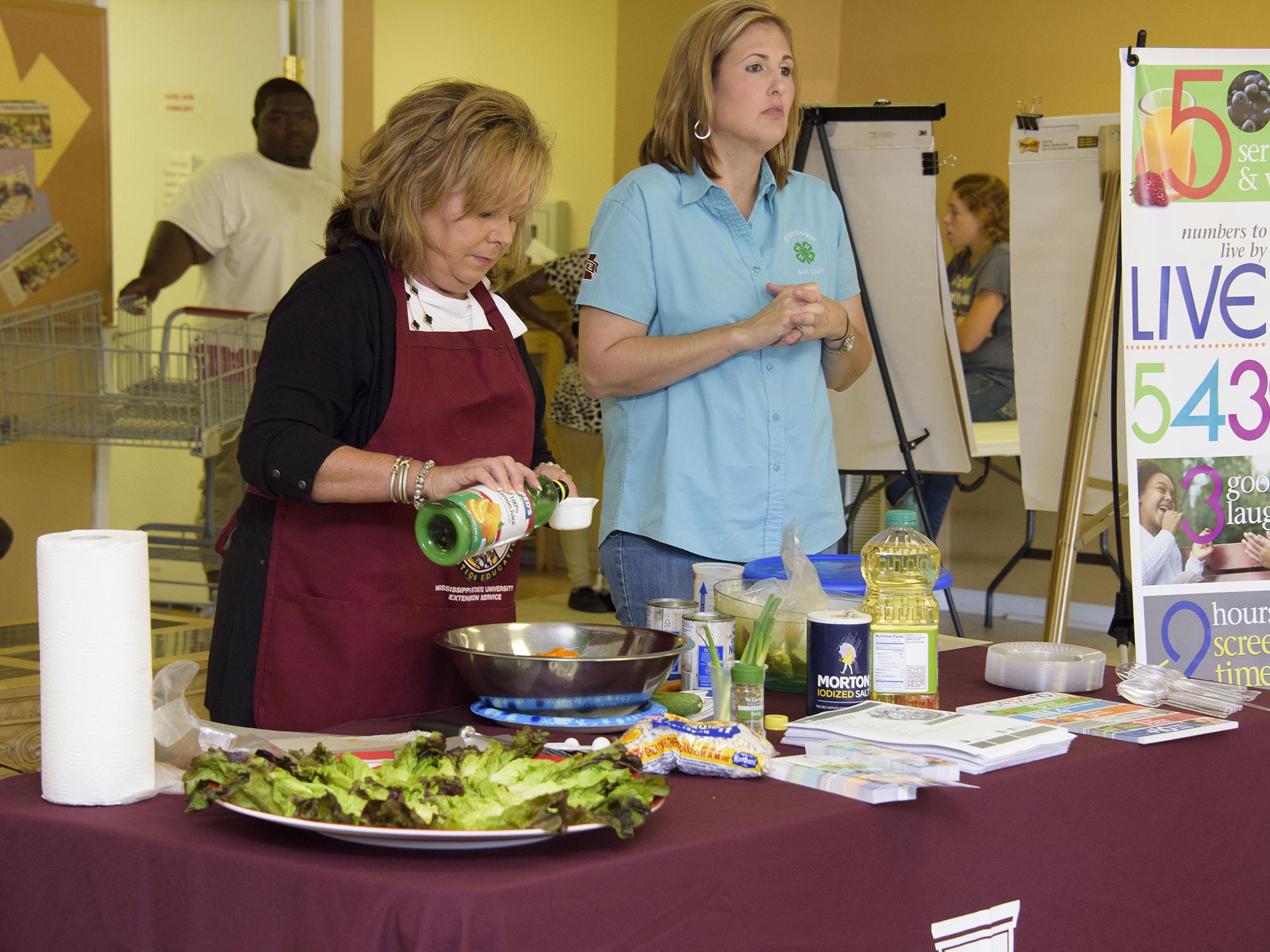 Angie Crawford, left, and Mari Alyce Earnest of the Mississippi State University Extension Service office in Quitman County deliver a nutrition education program Sept. 13, 2016, at the community center in Lambert, Mississippi. Extension works with several area organizations to provide food for about 800 underserved families every other month. (Photo by MSU Extension Service/Kevin Hudson)