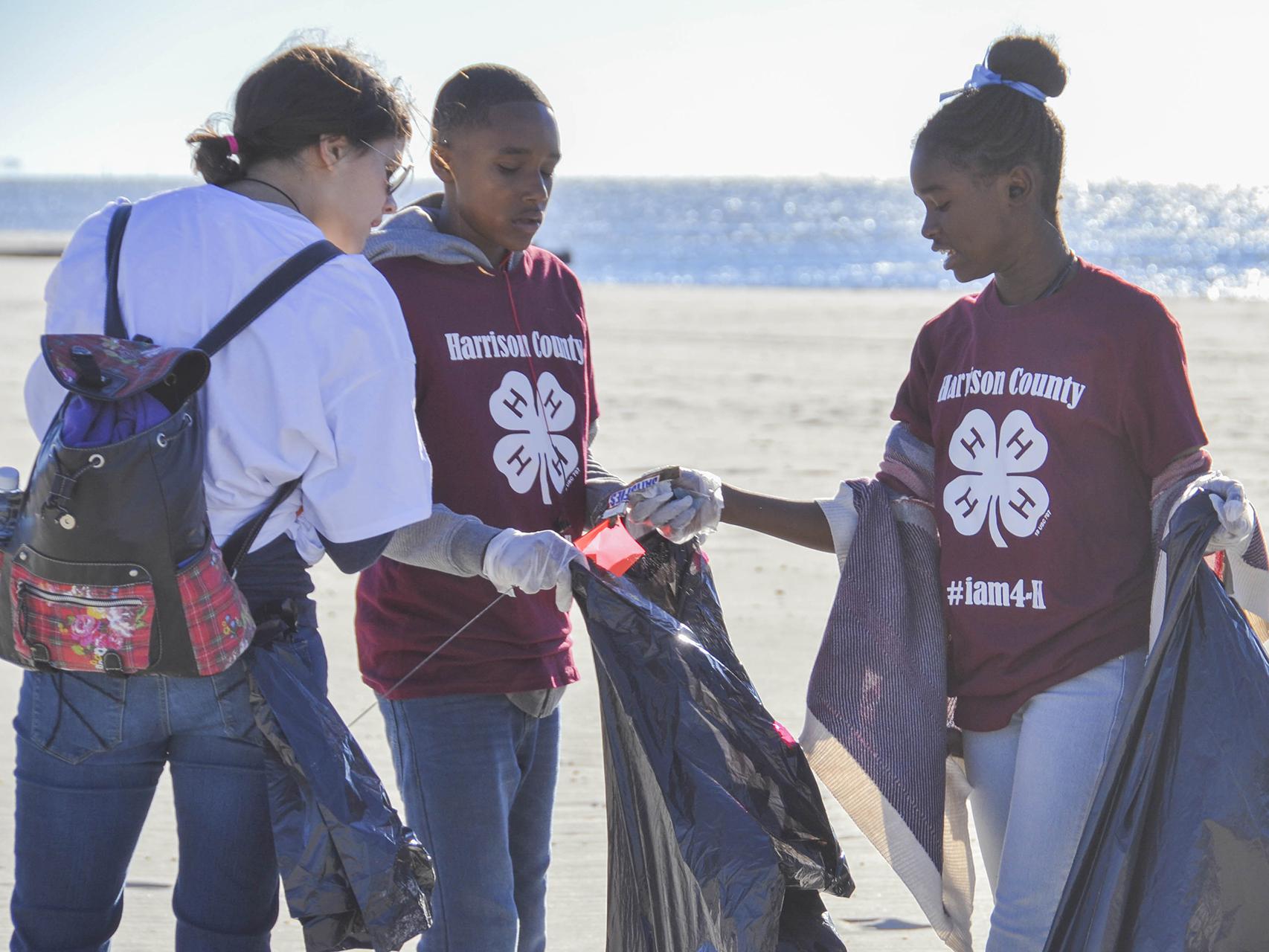 Jessica Lero, left, records the types of trash Kaileb Williams, center, and Laila Williams found while participating in the 2016 Mississippi Coastal Cleanup on Oct. 22 in Biloxi, Mississippi, with their Mississippi State University Extension Service 4-H club in Harrison County. They joined about 2,400 volunteers to collect more than an estimated 10 tons of trash during the 28th annual event. (Photo by MSU Extension Service/Susan Collins-Smith)