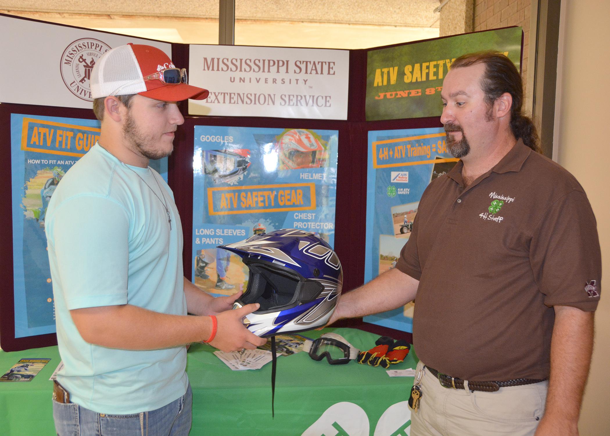 Parker Simpson of Choctaw County, left, talks with all-terrain vehicle safety instructor Brad Staton about the proper gear to wear while riding an ATV, including a helmet, eye protection and gloves. (Photo by MSU Ag Communications/Keri Collins Lewis)