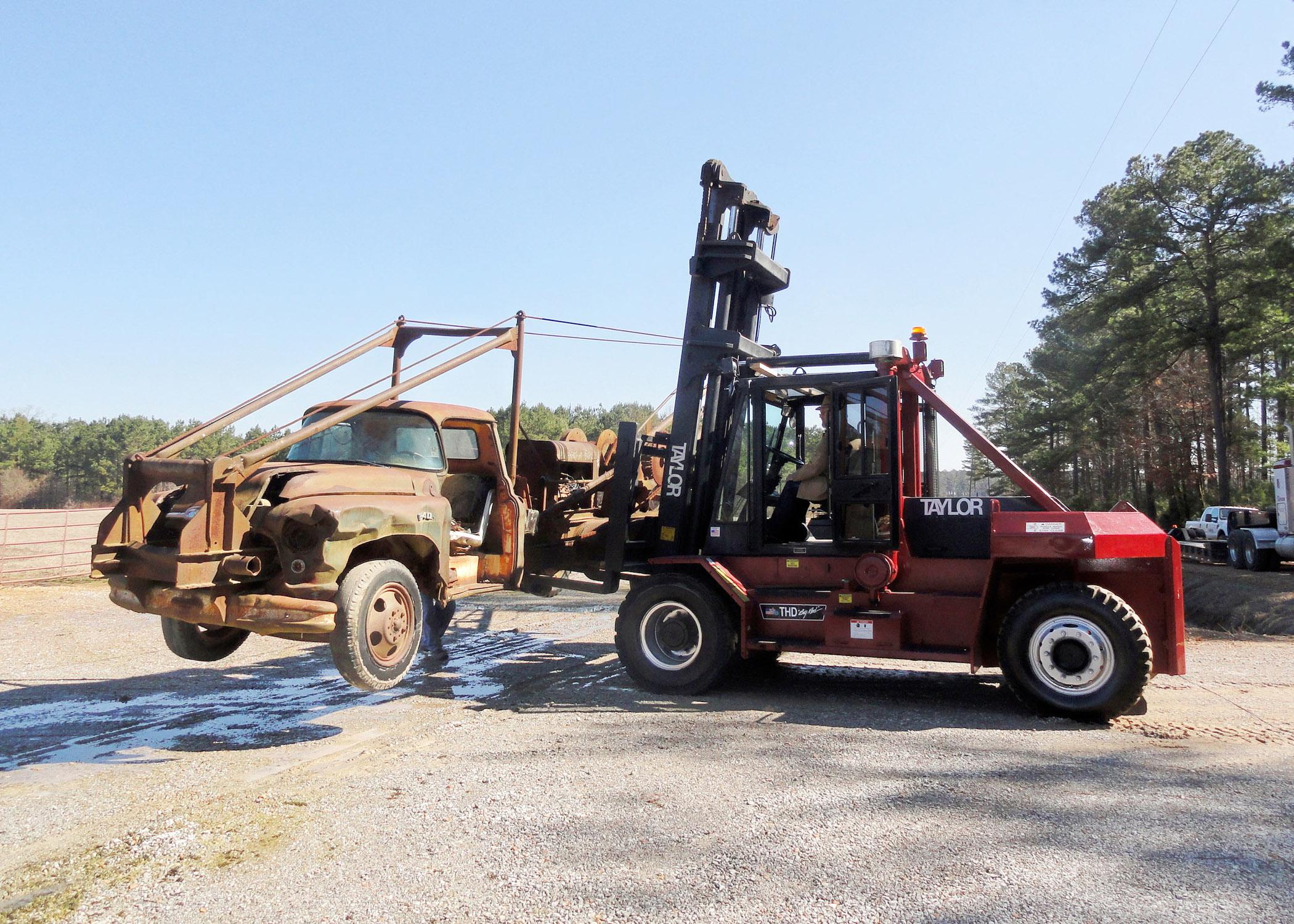 A staff member from Taylor Machine Works lifts a 1948 log loader to transport it to the company's Louisville, Miss., headquarters for restoration.  (File Photo by MSU Forest Operations/Misty Booth)