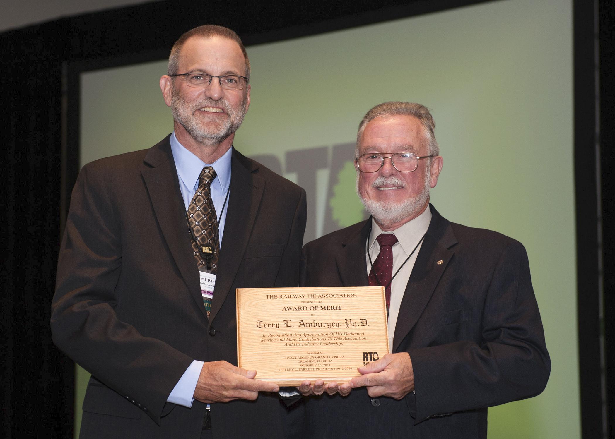 Jeff Parrett, currently of Wheeler Lumber and past president of the Railway Tie Association, left, presents Terry Amburgey, Mississippi State University professor emeritus and Giles Distinguished Professor, with the association's lifetime merit award. (Photo by Gary Coleman/Coleman Photography)